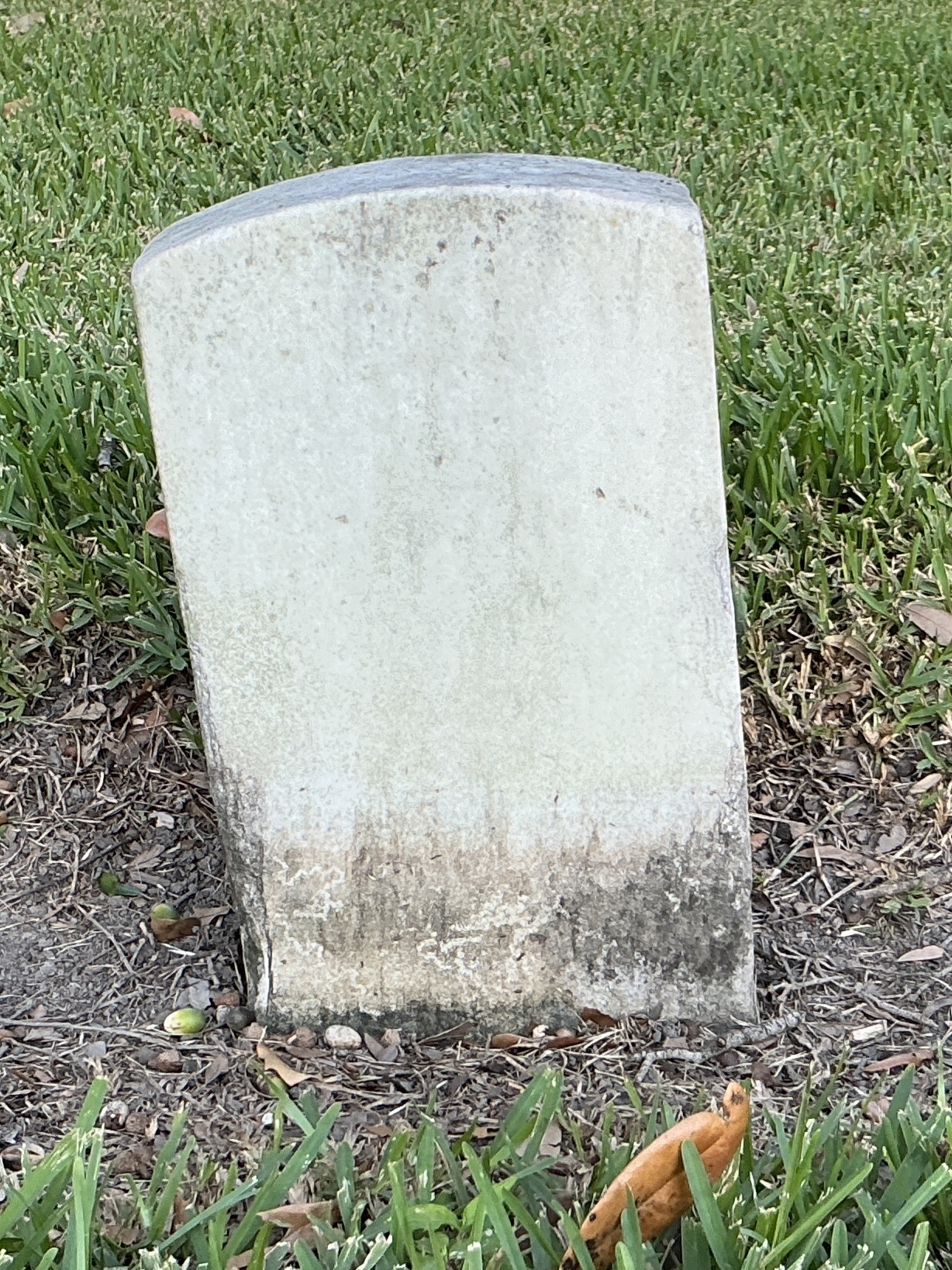 Back of historic upright marble headstone with recessed shield with recessed lettering face.