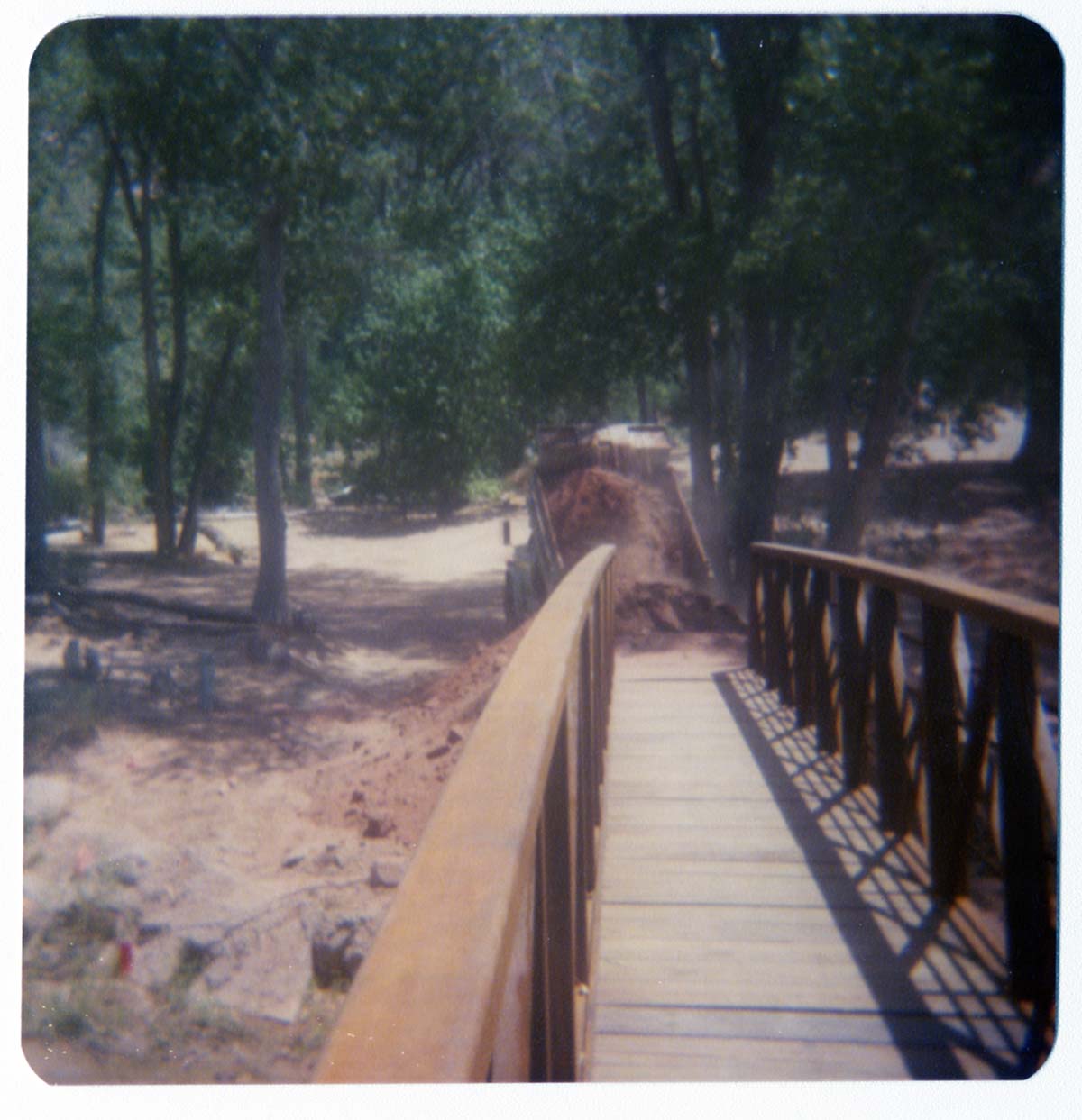 Dump truck unloading fill dirt at the base of new Grotto footbridge.