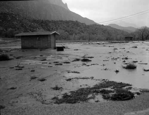 December 6, 1966 flood waters as they are beginning to recede- near Watchman amphitheater. View looking south, Eagle Crags in far background.