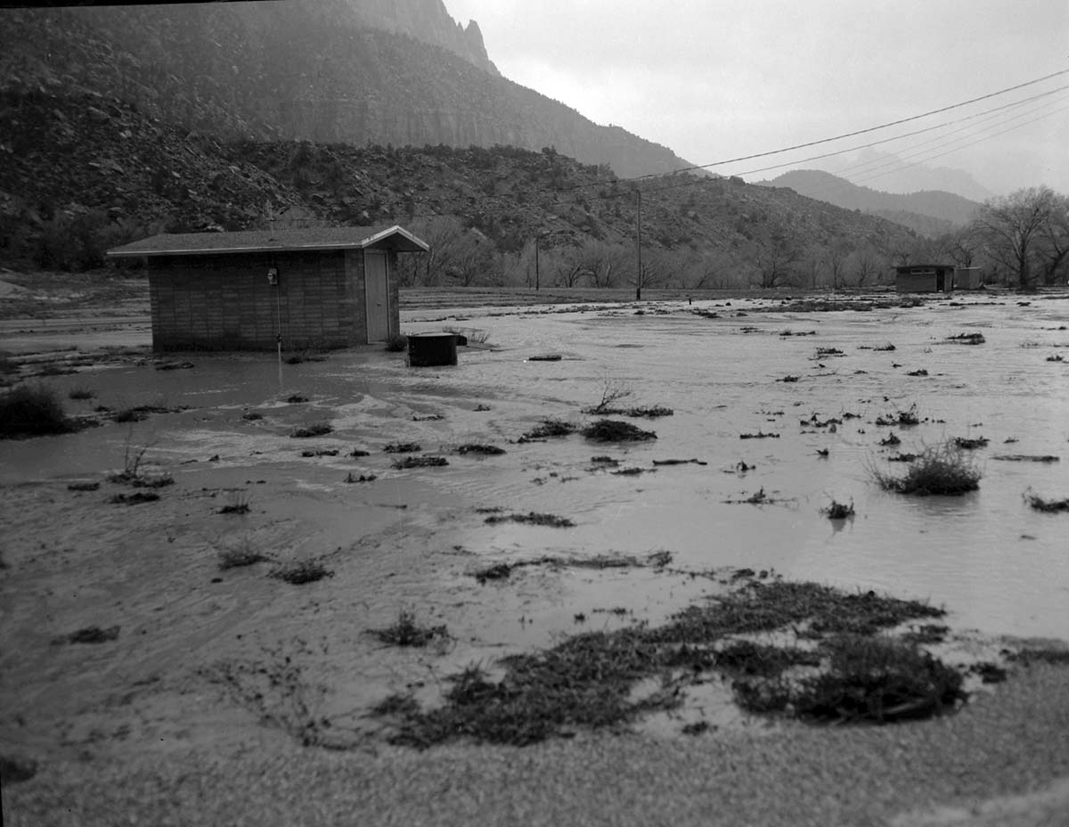 December 6, 1966 flood waters as they are beginning to recede- near Watchman amphitheater. View looking south, Eagle Crags in far background.