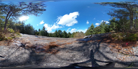 Spherical image of a rocky outcrop and trees with a view of nearby mountains