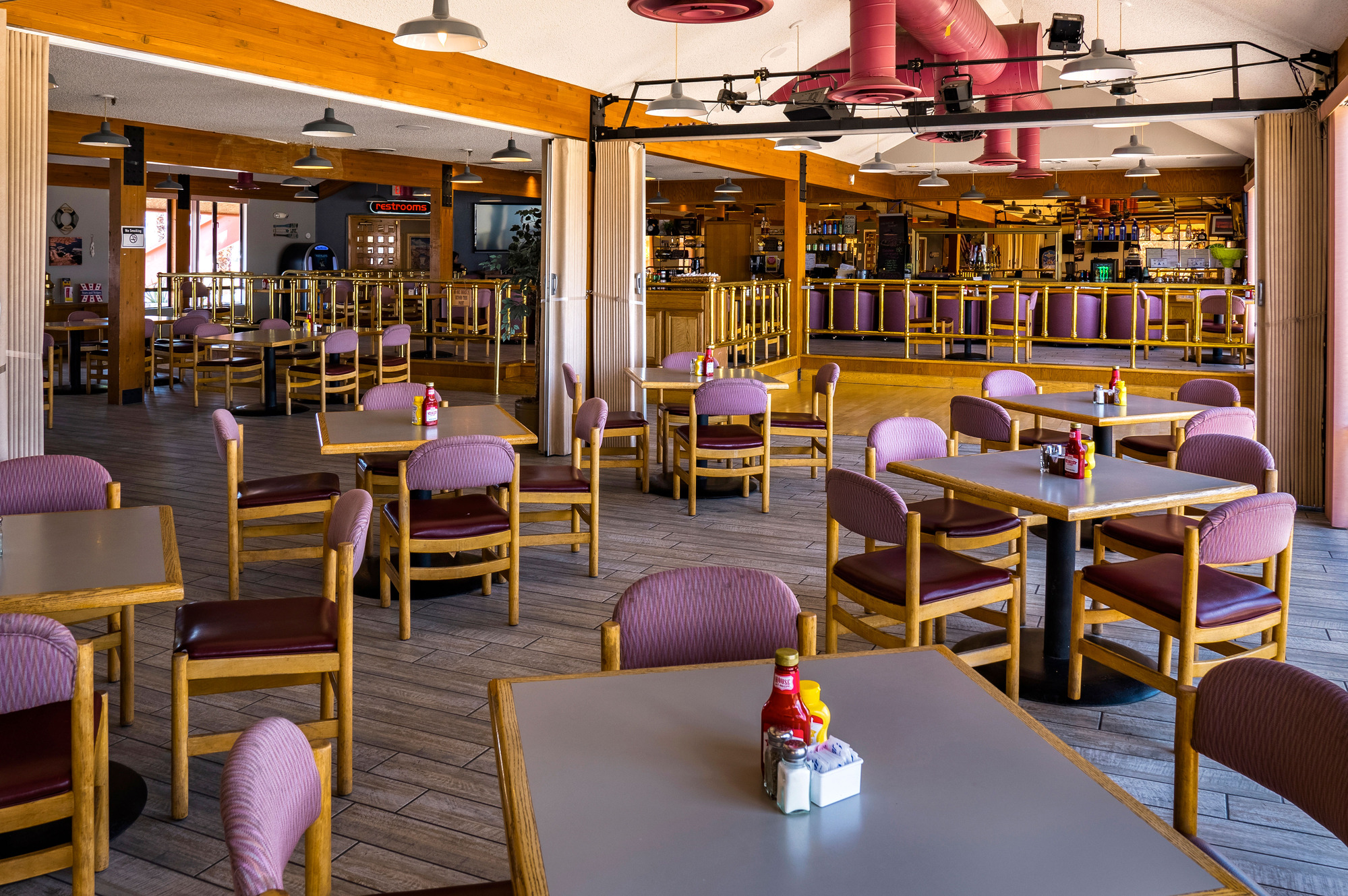 Empty tables, restaurant interior, wood fixtures, purple upholstery