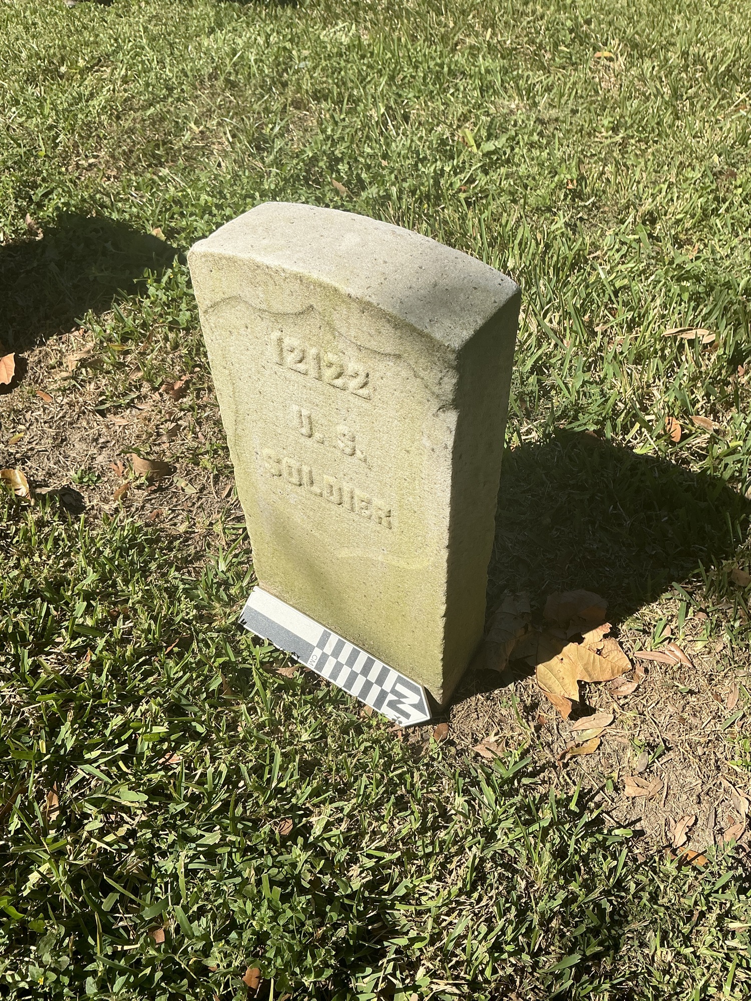 Back of historic upright marble headstone with recessed shield face.
