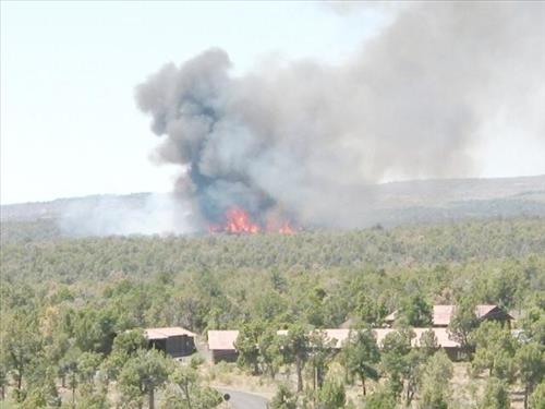 Full fire with black smoke advancing on buildings on the first day of Long Mesa Fire, Mesa Verde National Park, July 29, 2002