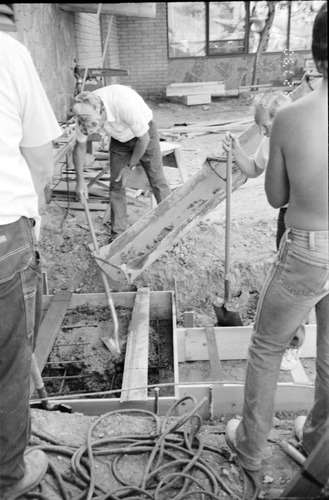 Workers laying cement during the construction of the headquarters addition.