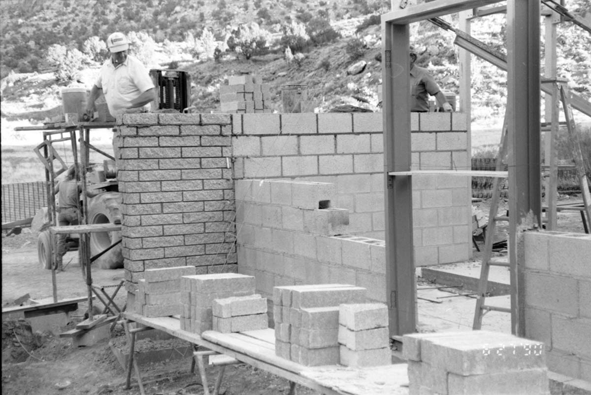 Workers building brick wall during the construction of the headquarters addition.