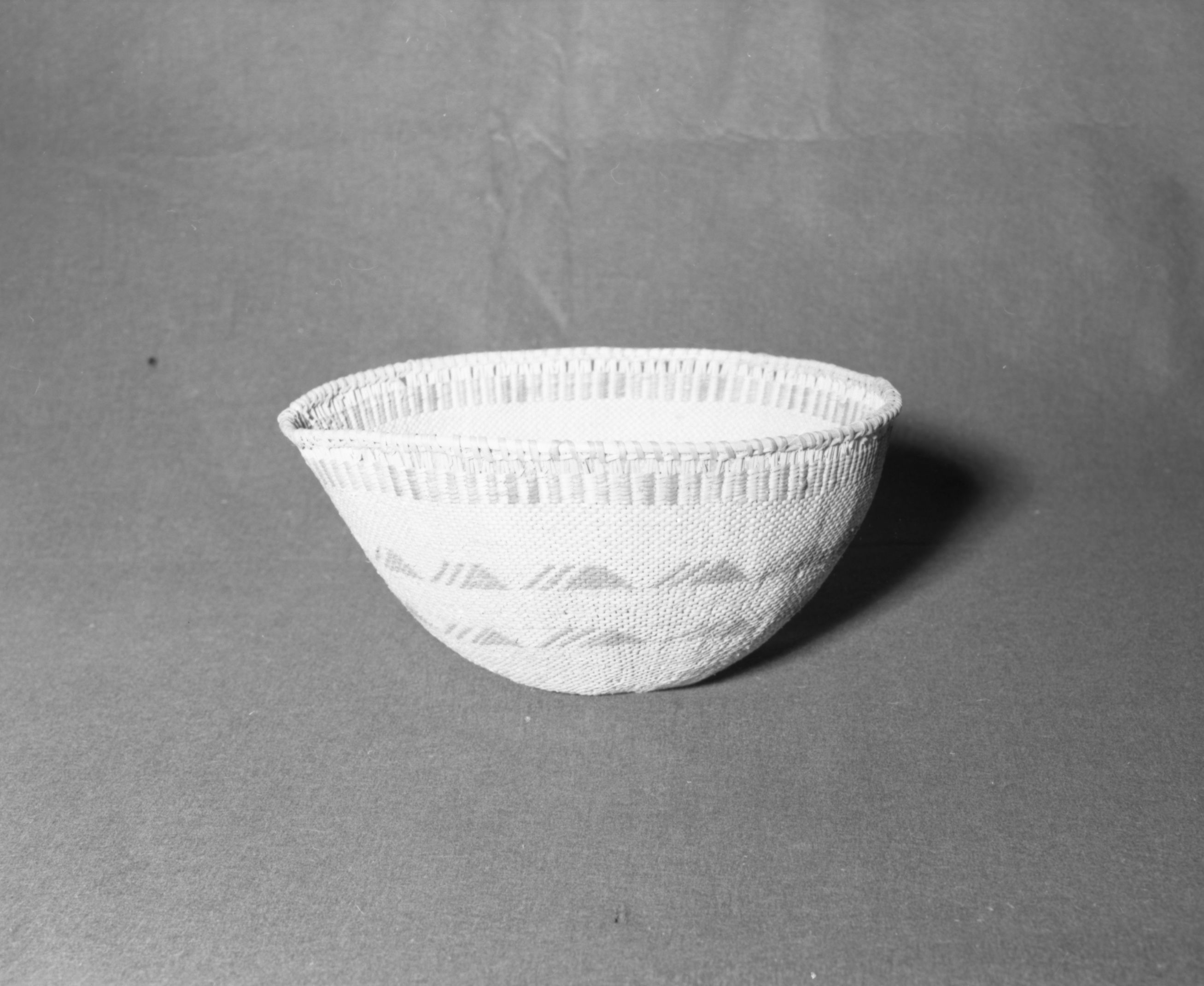 Mrs. Donald Segerstrom Collection. Object: Northern Paiute/Washoe basket. Dimensions: 13 1/2 x 6 1/2". Materials: entirely willow with design in sunburned willow touched up with dye. Technology: entirely diagonally twined with band of plain twining over grouped warps just below rim, warp rods over grouped warps just below rim, warp rods twined over each other and rimstick attached without the aid of an awl. Photographed by Michael Dixon, January 1983. Catalogued by Craig Bates and Barbara Beroza. Yosemite Collections, National Park Service.