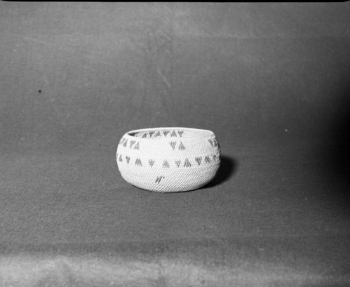 Mrs. Donald Segerstrom Collection. Object: Miwok basket. Dimensions: 6-3/4 x 3 1/4". Materials: Red bud, split willow (?). Technology: Interlocking stitch, leftward coil direction, simple rim finish, clockspring start, fag ends trimmed on workface, moving ends trimmed on interior. Photographed by Michael Dixon. Catalogued by Craig Bates and Barbara Beroza. Yosemite Collections, National Park Service. 1/83.