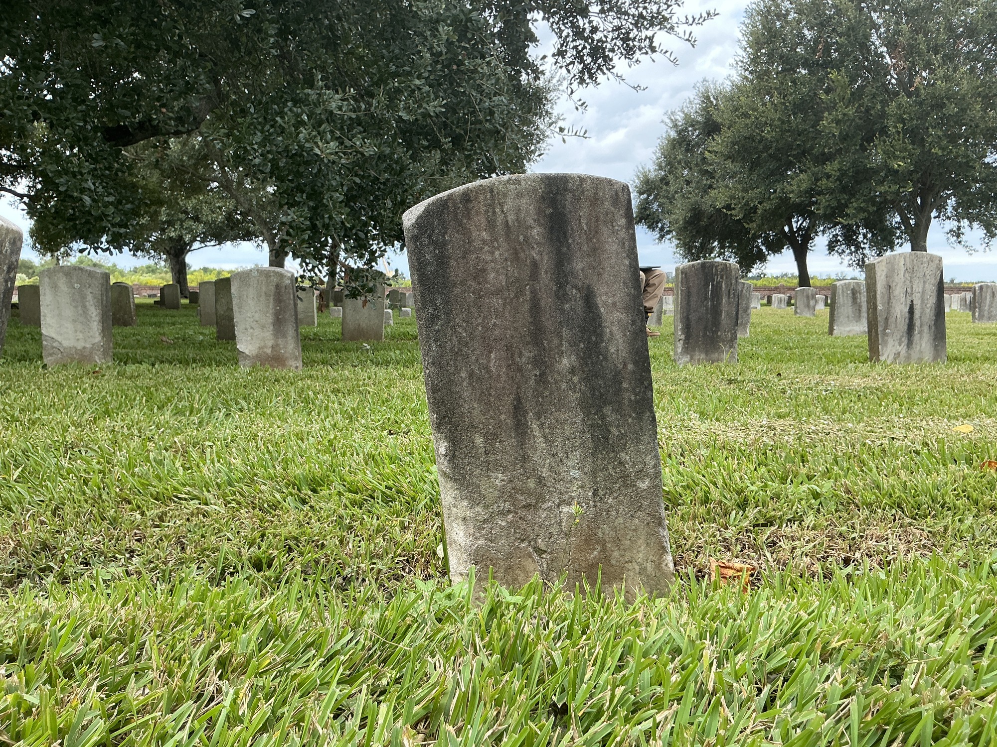Back of historic upright marble headstone with recessed shield face.