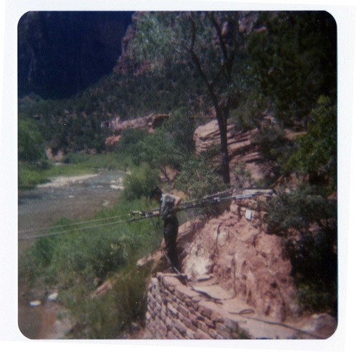Man tightening cables for pulley system to move new Grotto footbridge across the Virgin River.
