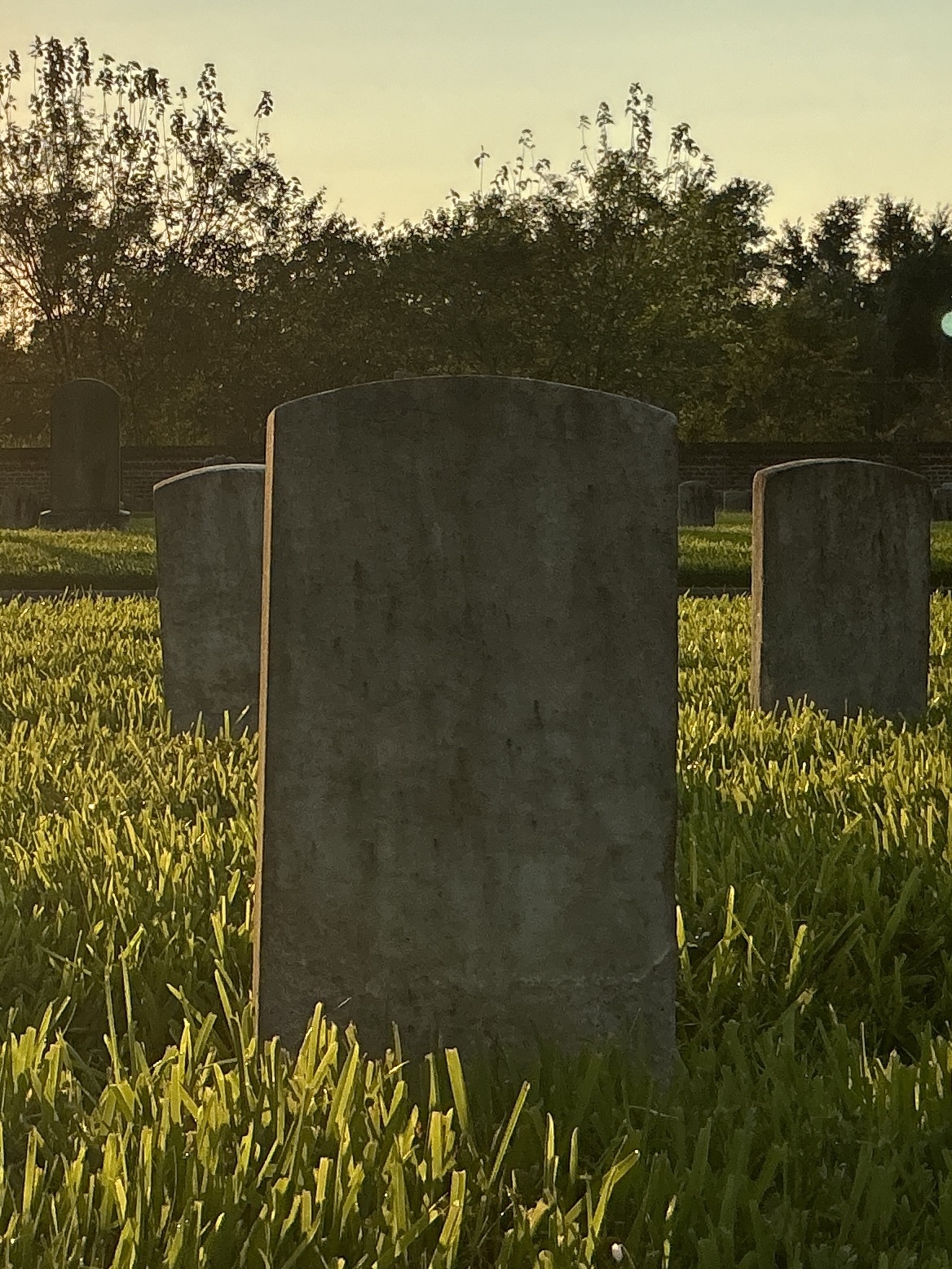 Back of historic upright marble headstone with recessed shield face.