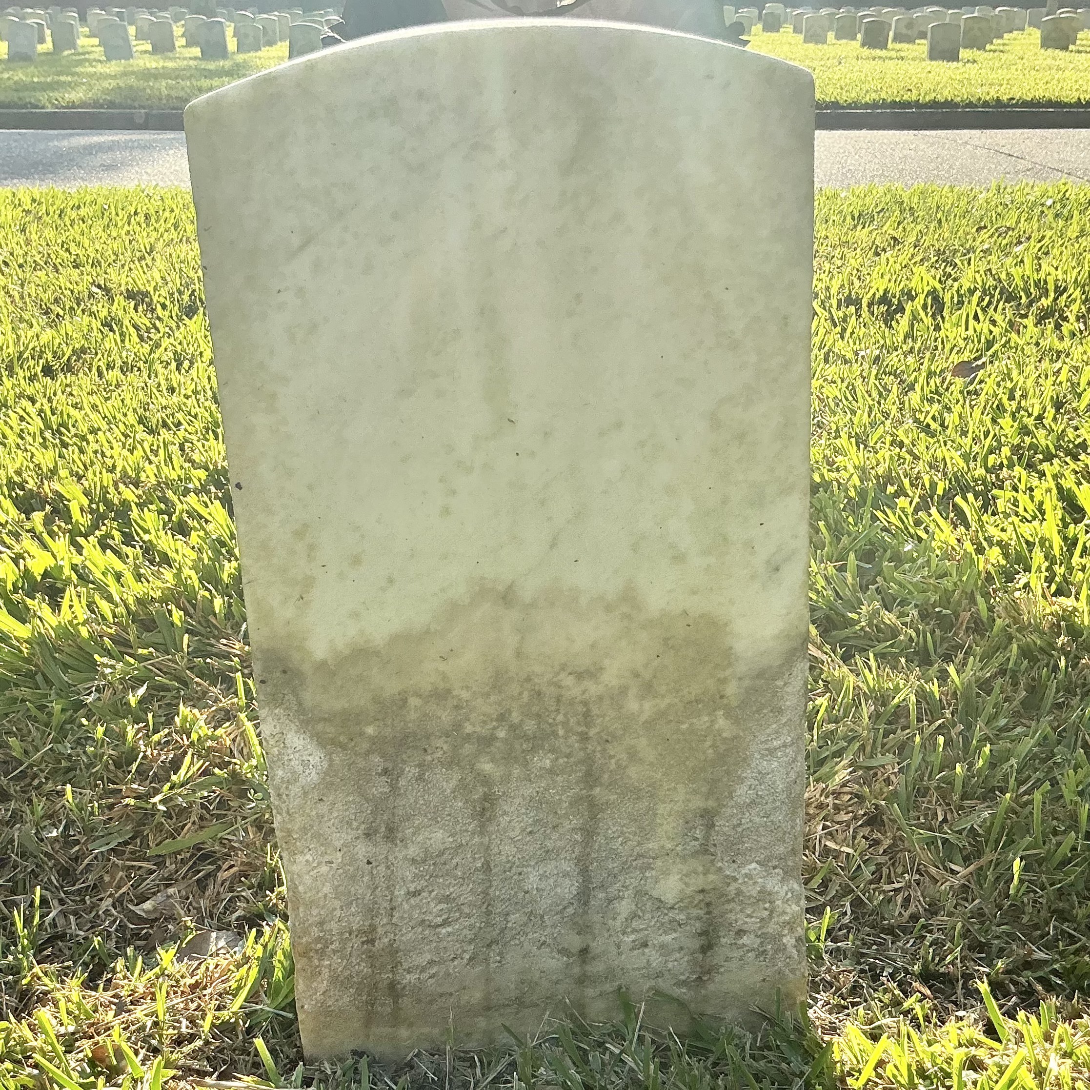 Back of historic upright marble headstone with recessed shield face.