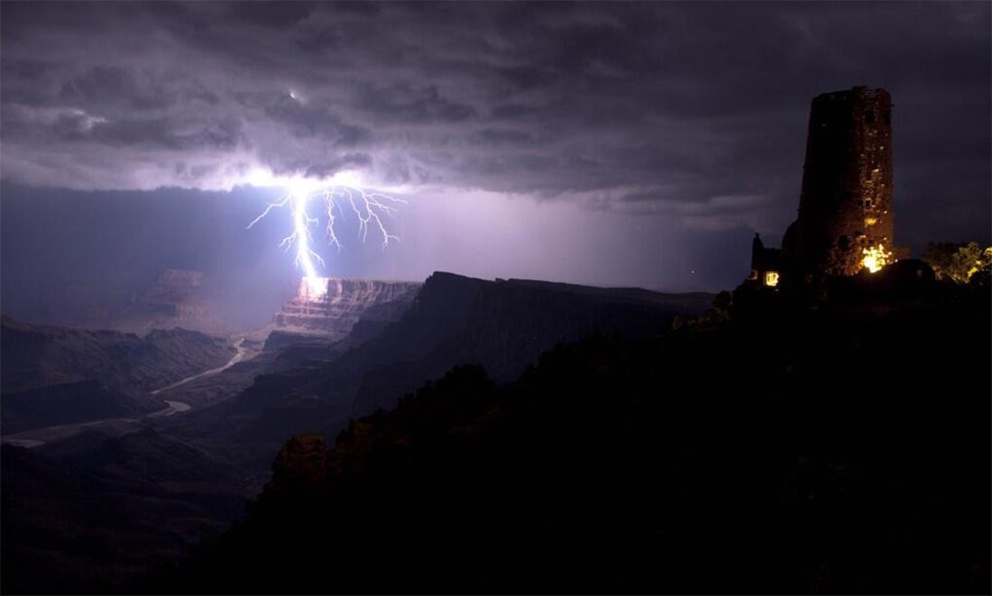 A lighting strike from a thunderstorm illuminates the Grand Canyon.