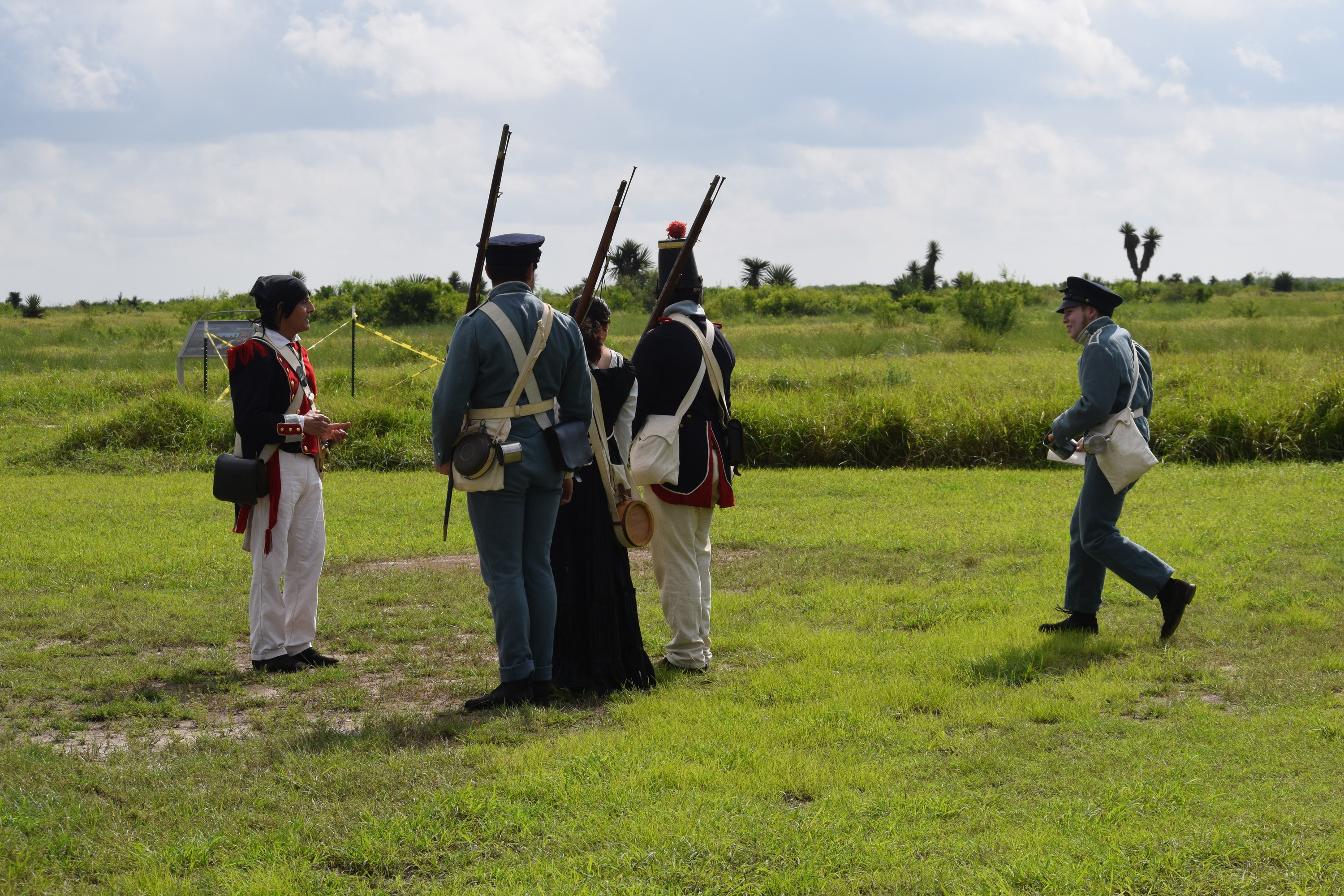 Volunteers in historic attire stand at Shoulder arms.