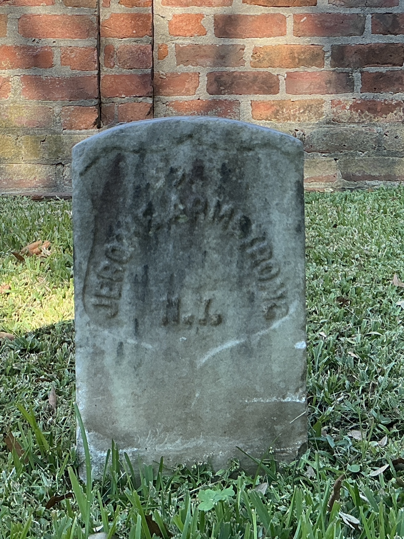 Front of historic upright marble headstone with recessed shield face.