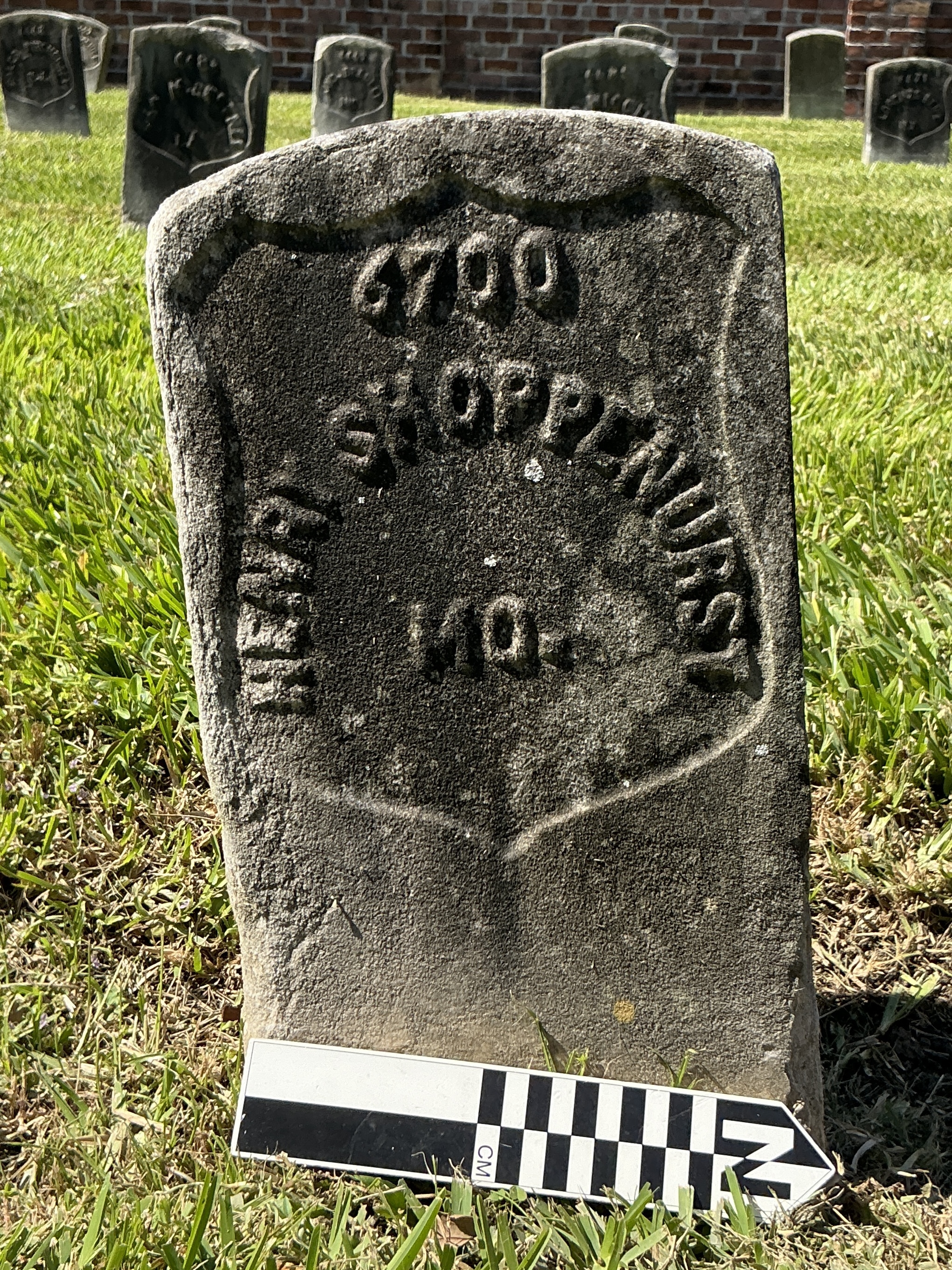 Extra image of historic upright marble headstone with recessed shield face.