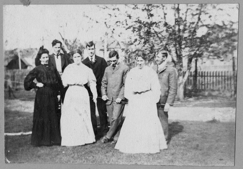 Mrs. Madge Gates Wallace, left, wears black and is posing with family and friends.
