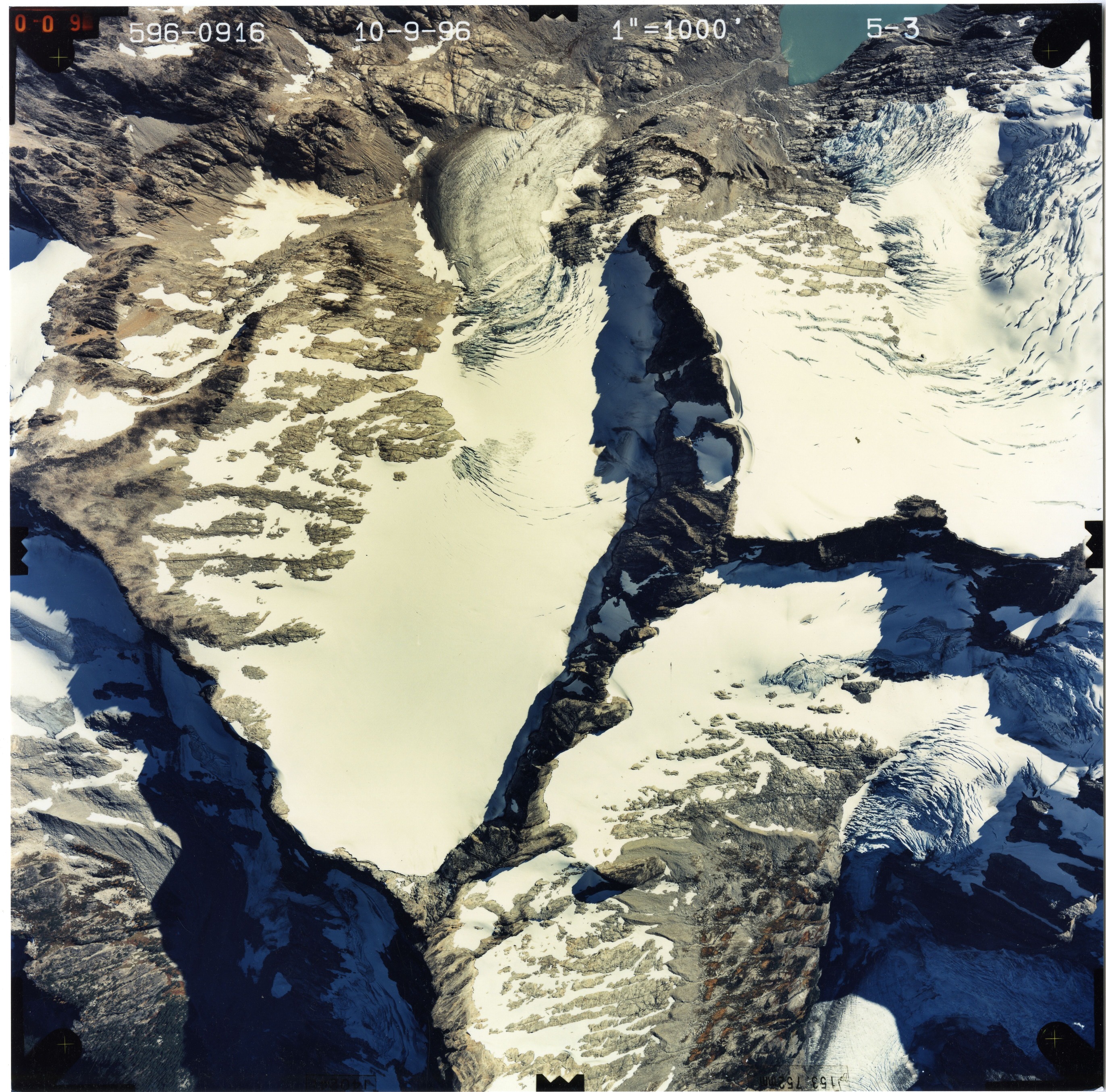 Color aerial photograph of glacier and snowfields on mountain peak.