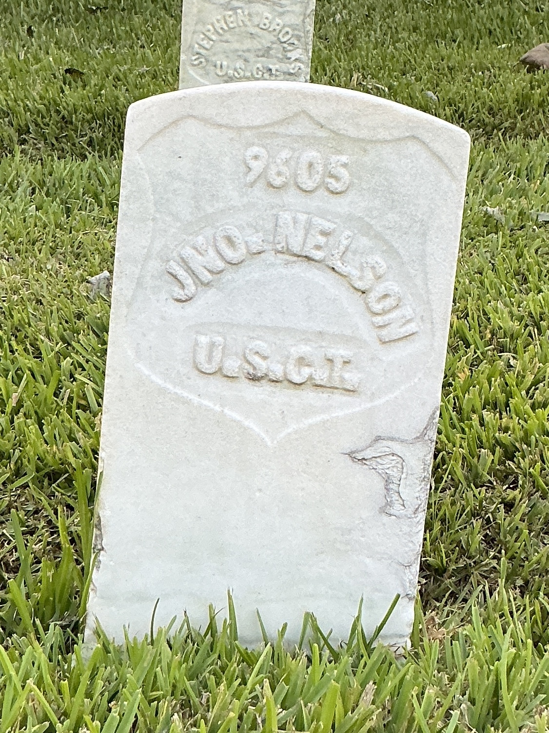 Front of historic upright marble headstone with recessed shield face.
