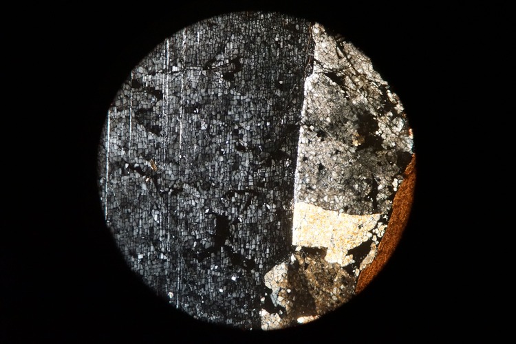 Circular microscopic image of rock structure.