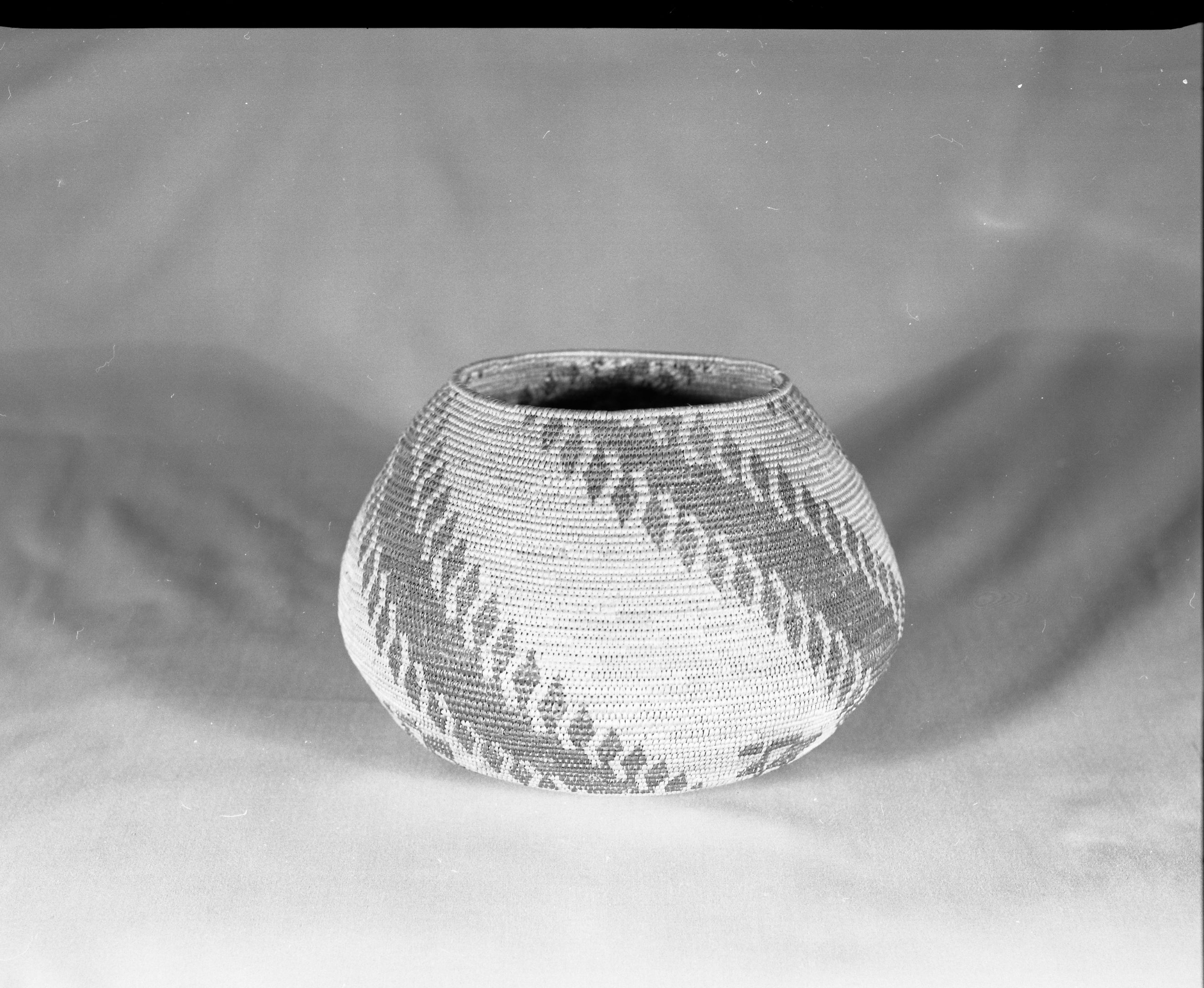 Private Collection. Object: Maidu type basket. Dimensions: 9 x 6 1/2". Materials: Sedge root and redbud. Technology: Tight spiral start, fag ends concealed in foundation, moving ends bound under, stitched split on interior. Photographed by Michael Dixon. Catalogued by Craig Bates and Barbara Beroza. Yosemite Collections, National Park Service.