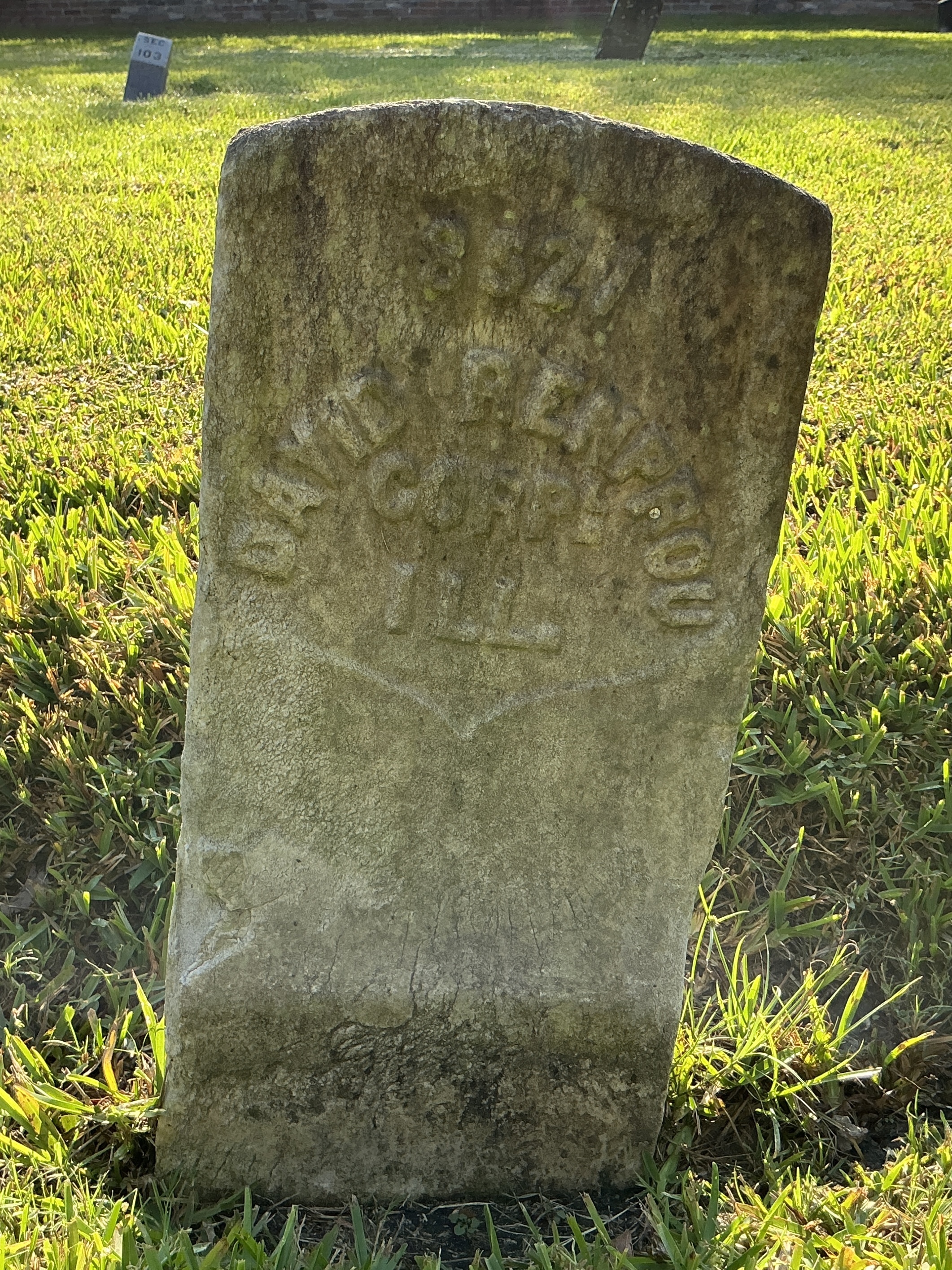 Front of historic upright marble headstone with recessed shield face.