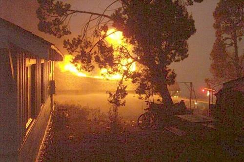 Night photos of a house burning during the Long Mesa fire in Mesa Verde National Park, July-August 2002