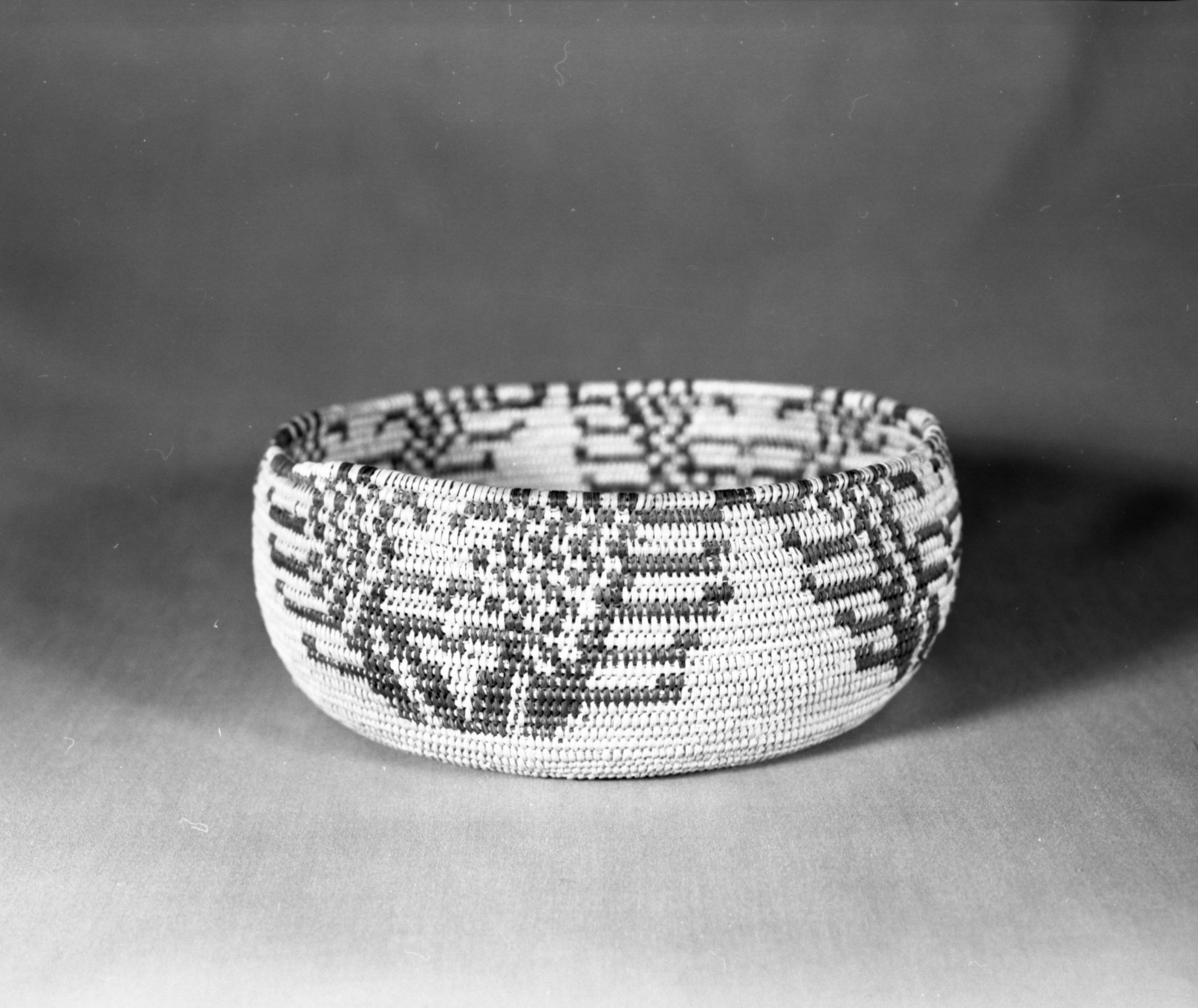 Private Collection. Object: Miwok basket. Dimensions: 9 x 3 1/2". Materials: Bracken fern root, split shoot probably maple. Technology: Clockspring start, interlocking stitch, three rod. Fag ends trimmed on work face, moving ends trimmed on interior. Collection History: Calaveras County. (Possibly from Arollas family, Angels Camp area). Photographed by Michael Dixon. Catalogued by Craig Bates and Barbara Beroza. Yosemite Collections, National Park Service.