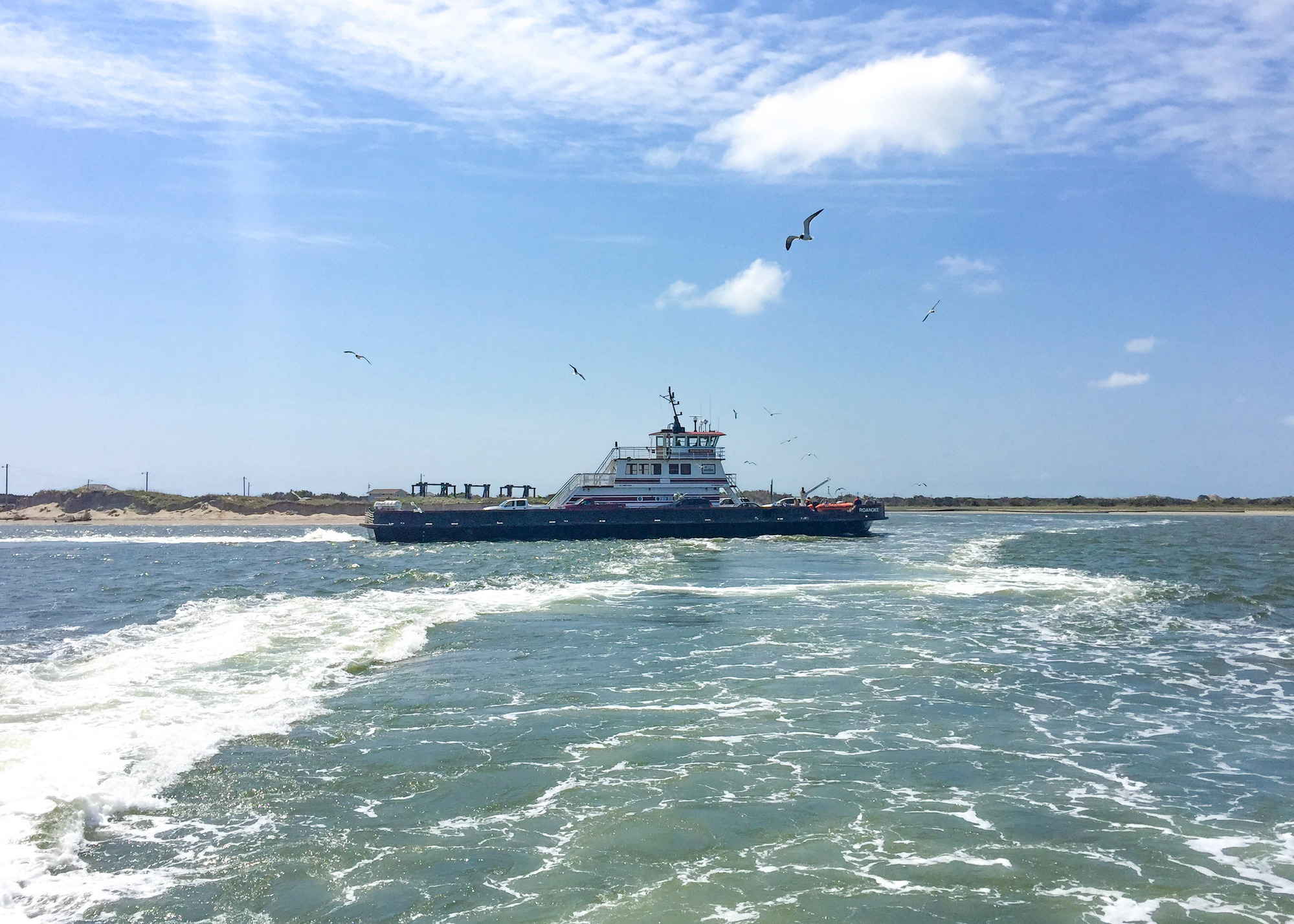 Seagulls flying over a vehicle ferry