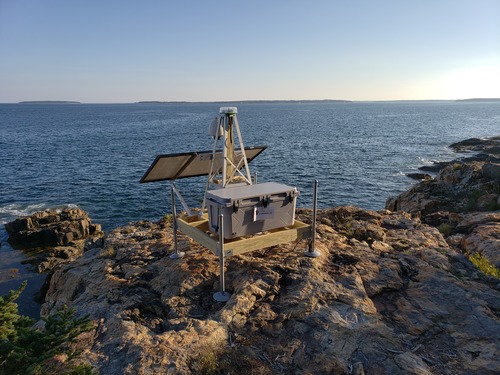 Wood platform on steel legs with small tower, webcam, and solar panel.