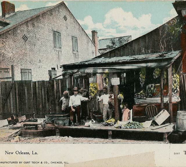 illustrated postcard of a "typical Italian fruit stand": a wooden awning and platform on a dirt road are covered in fruits, a few people stand around it. 