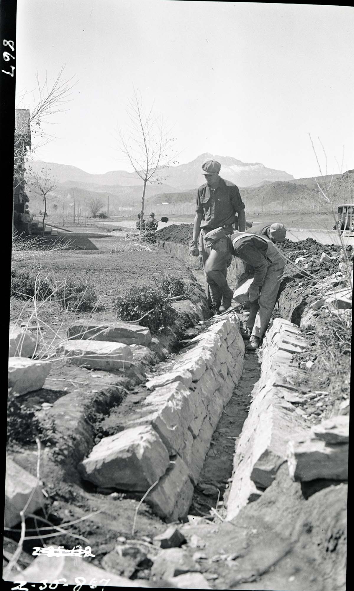 Construction of irrigation ditches in front of cafeteria, Camp Center, South Entrance.
