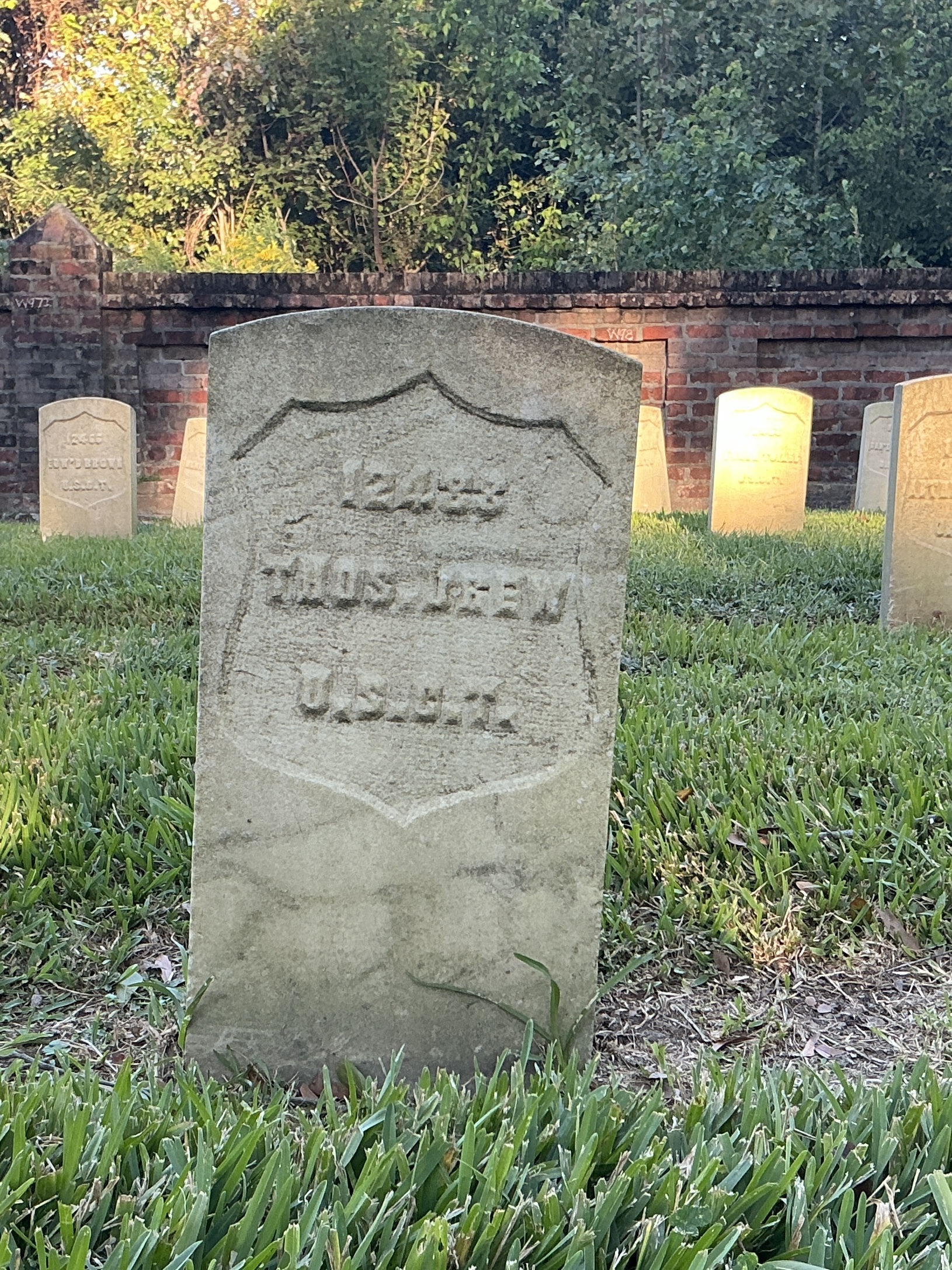 Front of historic upright marble headstone with recessed shield face.