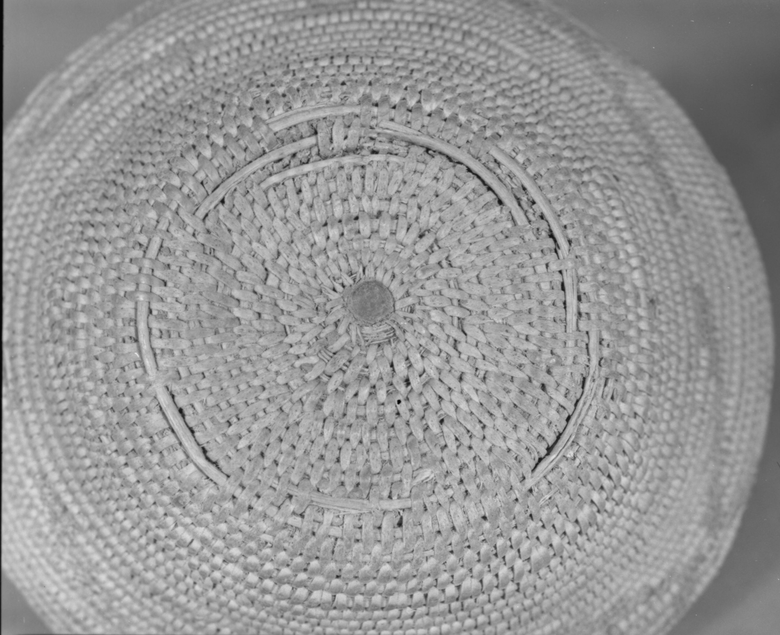 Private Collection. Object: Miwok basket. Dimensions: 7 1/4 x 2 1/2". Materials: Split shoots, bracken fern root. Technology: Interlocking stitch, three rods, fag ends trimmed on workface, moving ends trimmed on interior. Clockspring start filled by jamming whole stick in start. Original rim is missing. Encrusted with acorn mush. Collection History: Purchased from Maggie Longfellow's mother, also known as Mrs. Lonfellow Poncho. Photographed by Michael Dixon. Catalogued by Craig Bates and Barbara Beroza. Yosemite Collections, National Park Service.