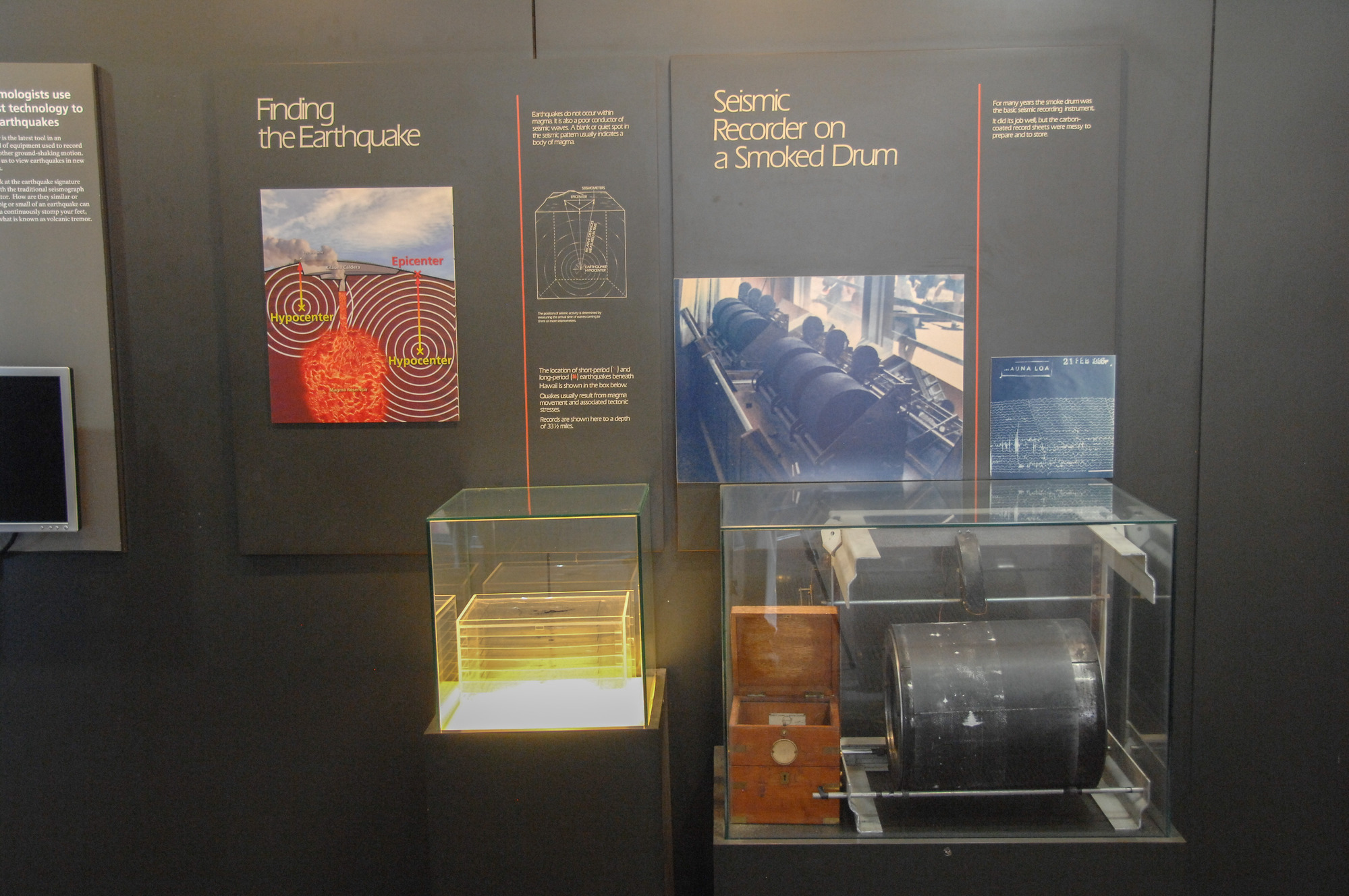 Exhibit with an old-fashioned seismometer and acrylic plates mounted on a wall. 