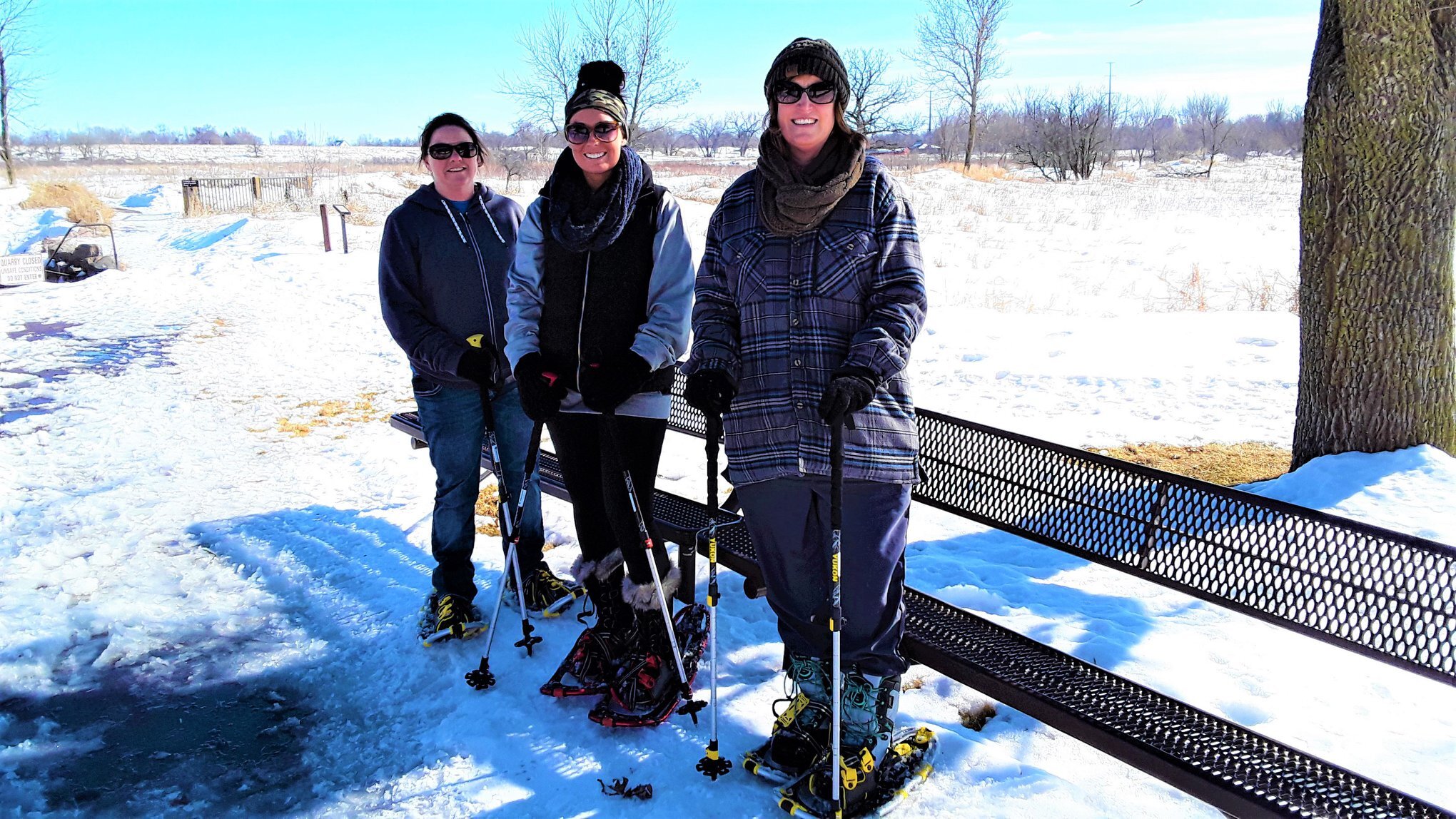 Three women in snowshoes smiling
