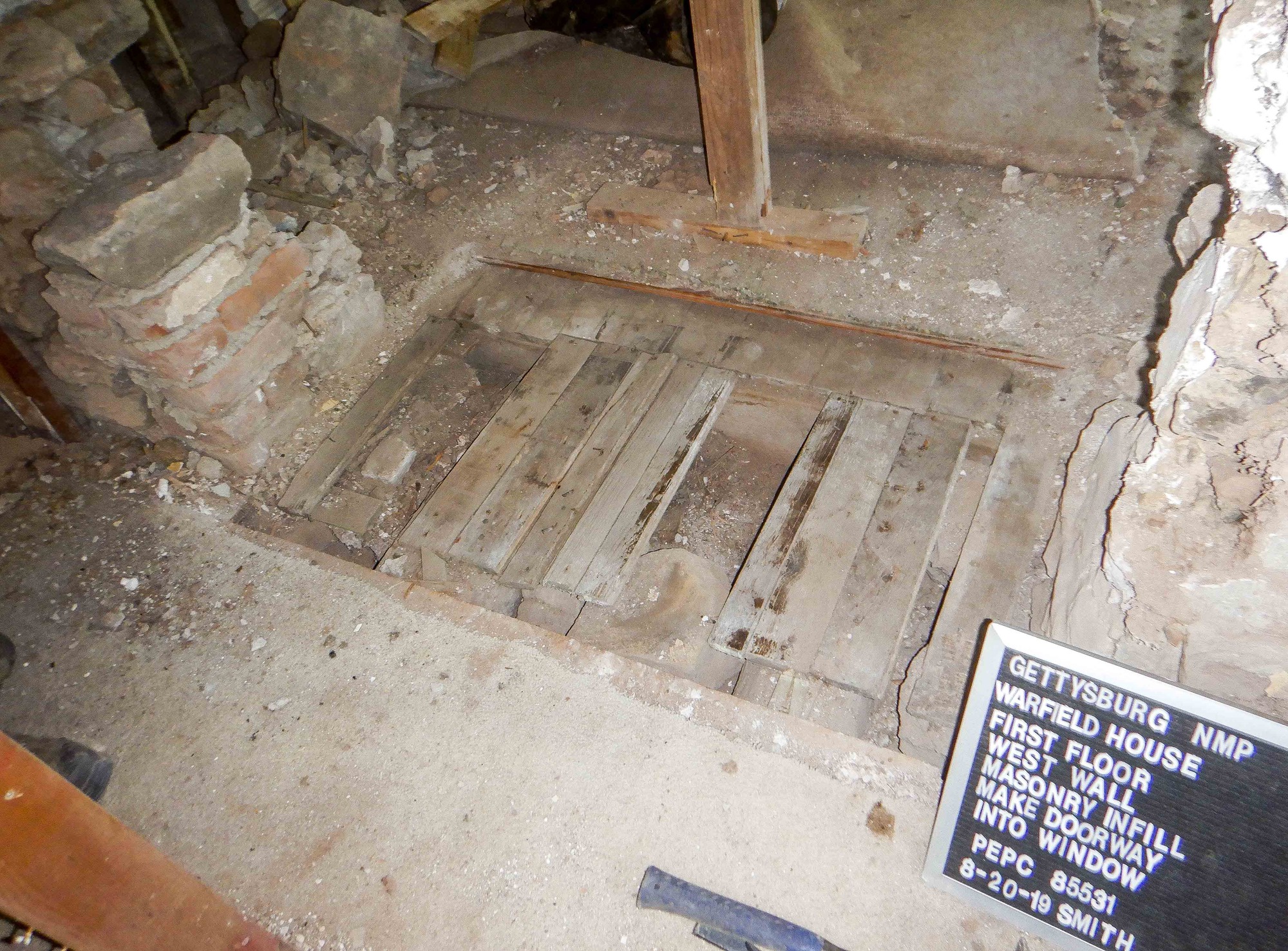 Non historic wooden flooring has been exposed between two walls of brick and stone.