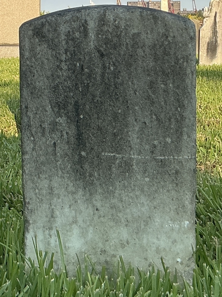 Back of historic upright marble headstone with recessed shield face.