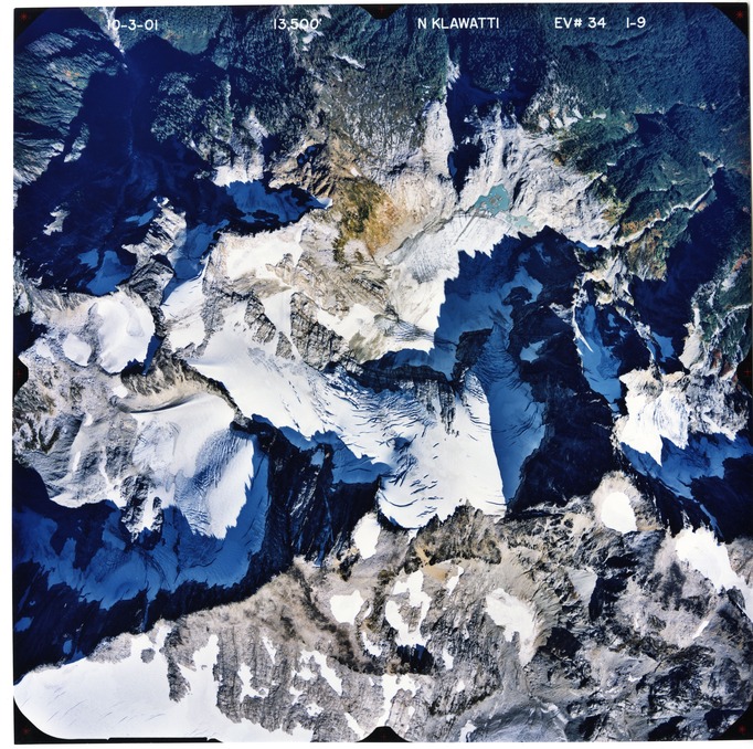 Color aerial photograph of glacier and snowfields on mountain peak.