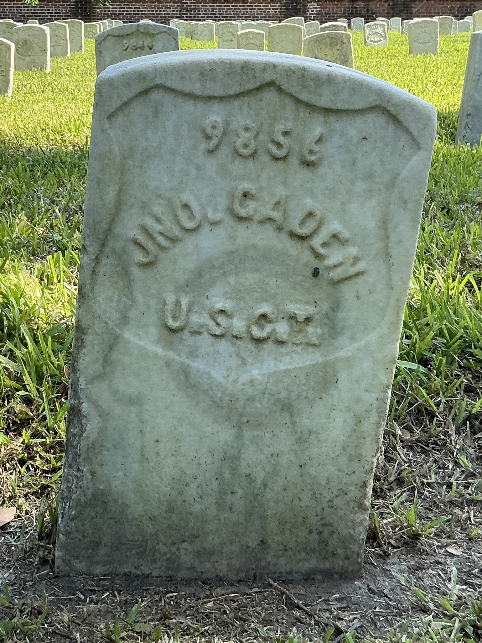 Front of historic upright marble headstone with recessed shield face.