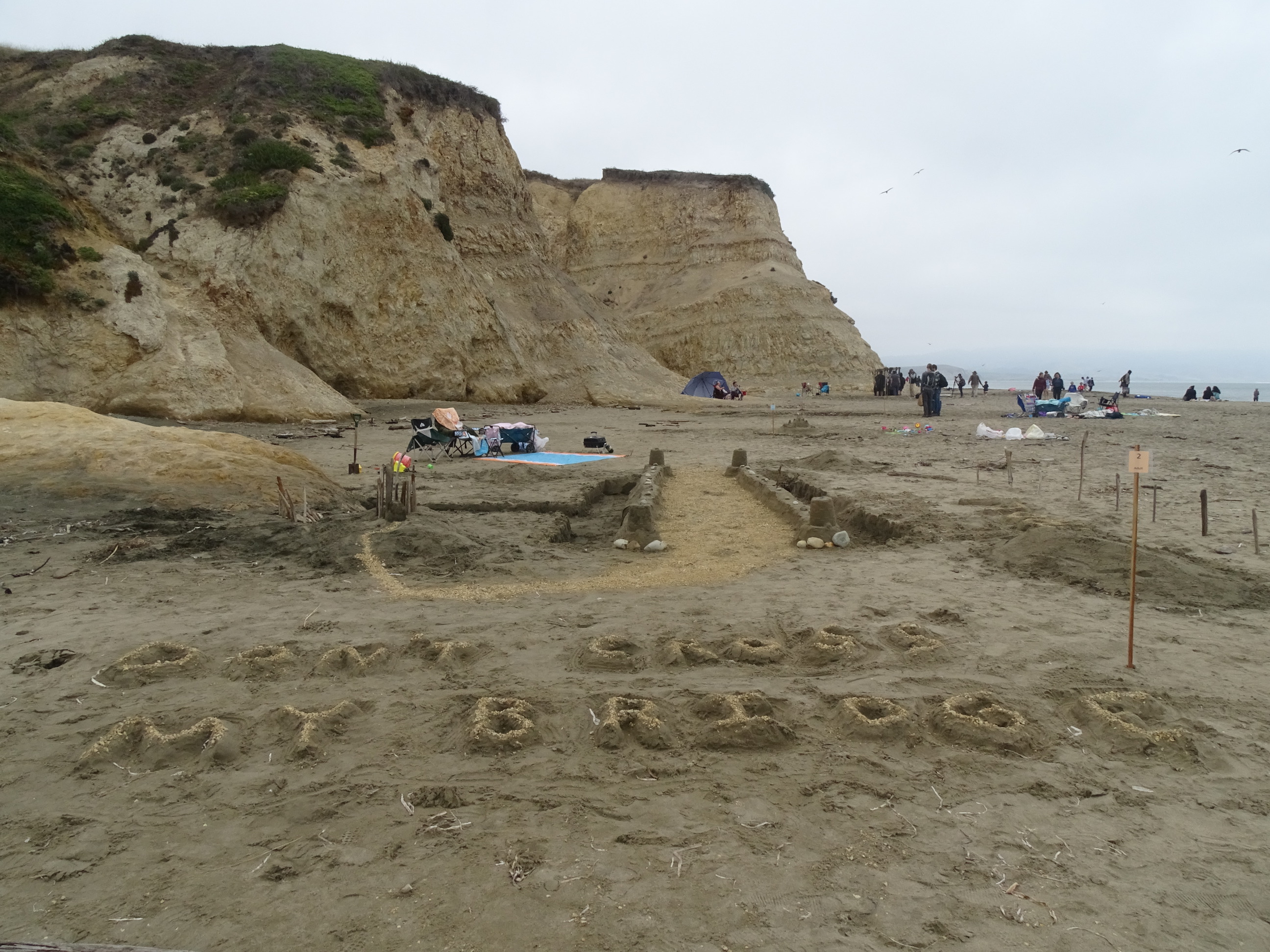 A large sand sculpture of a bridge with the phrase "Don't Cross My Bridge" in the foreground.