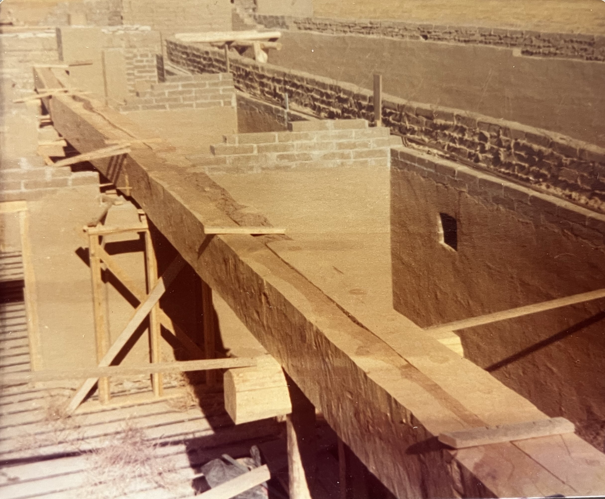 A series of long wooden beams in line are seen in the east range of rooms. The vertical support seen in the foreground is in the dining room. 