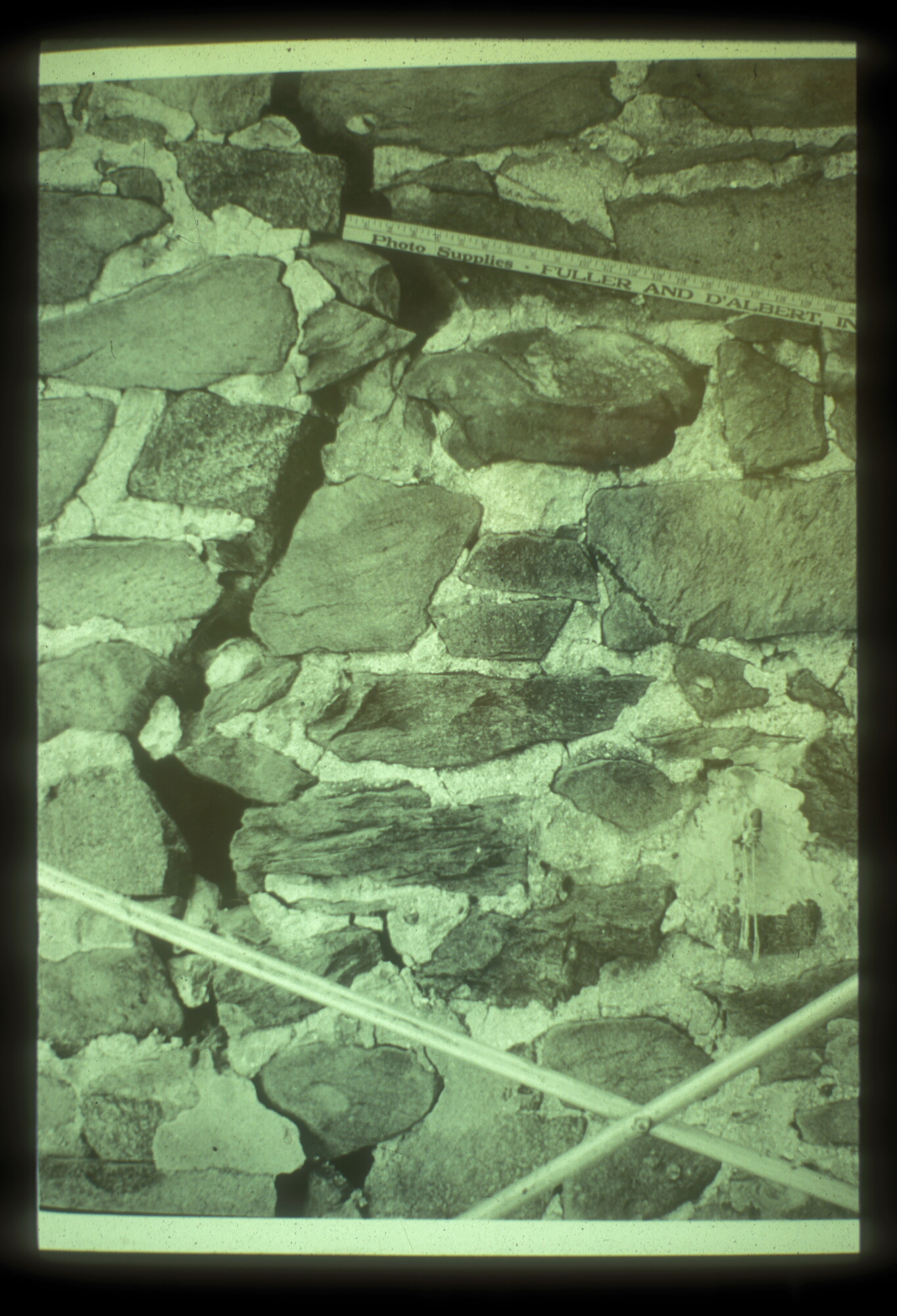 A measuring stick illustrates how large a crack is between two sections of stone