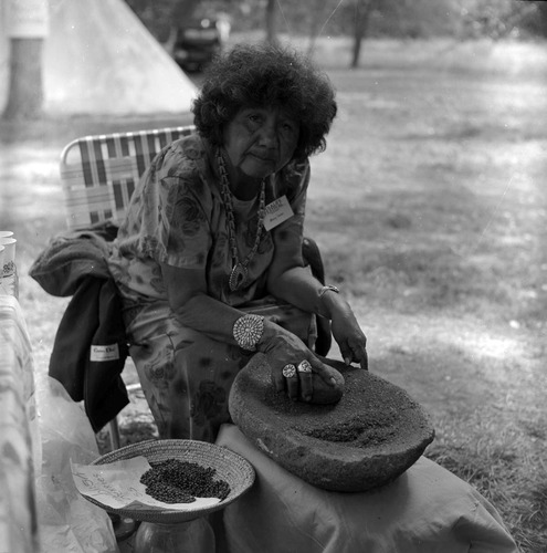 Mary Snow, Paiute, demonstrating grinding with a metate and mano at the first annual Folklife Festival at Nature Center at Zion National Park, September 1977.