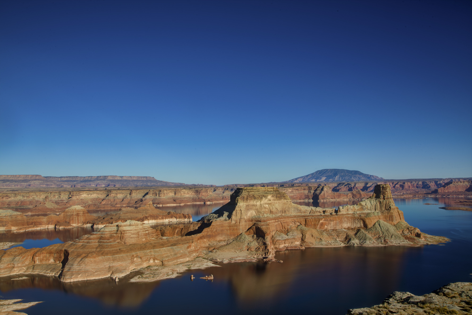 Sandstone cliffs, lake, mountain, sky.