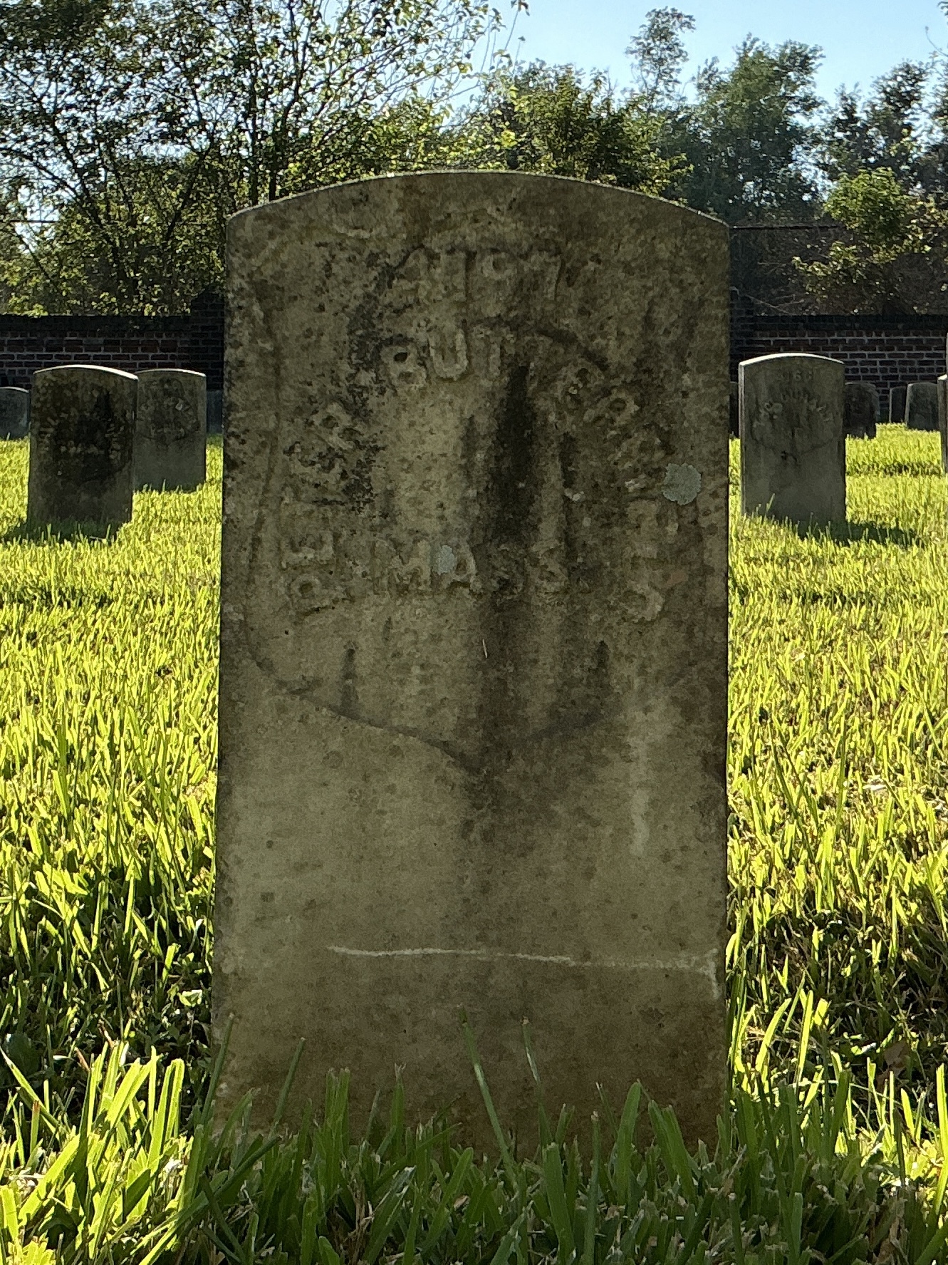 Front of historic upright marble headstone with recessed shield face.