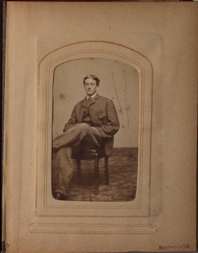 Black and white photograph of seated young man.