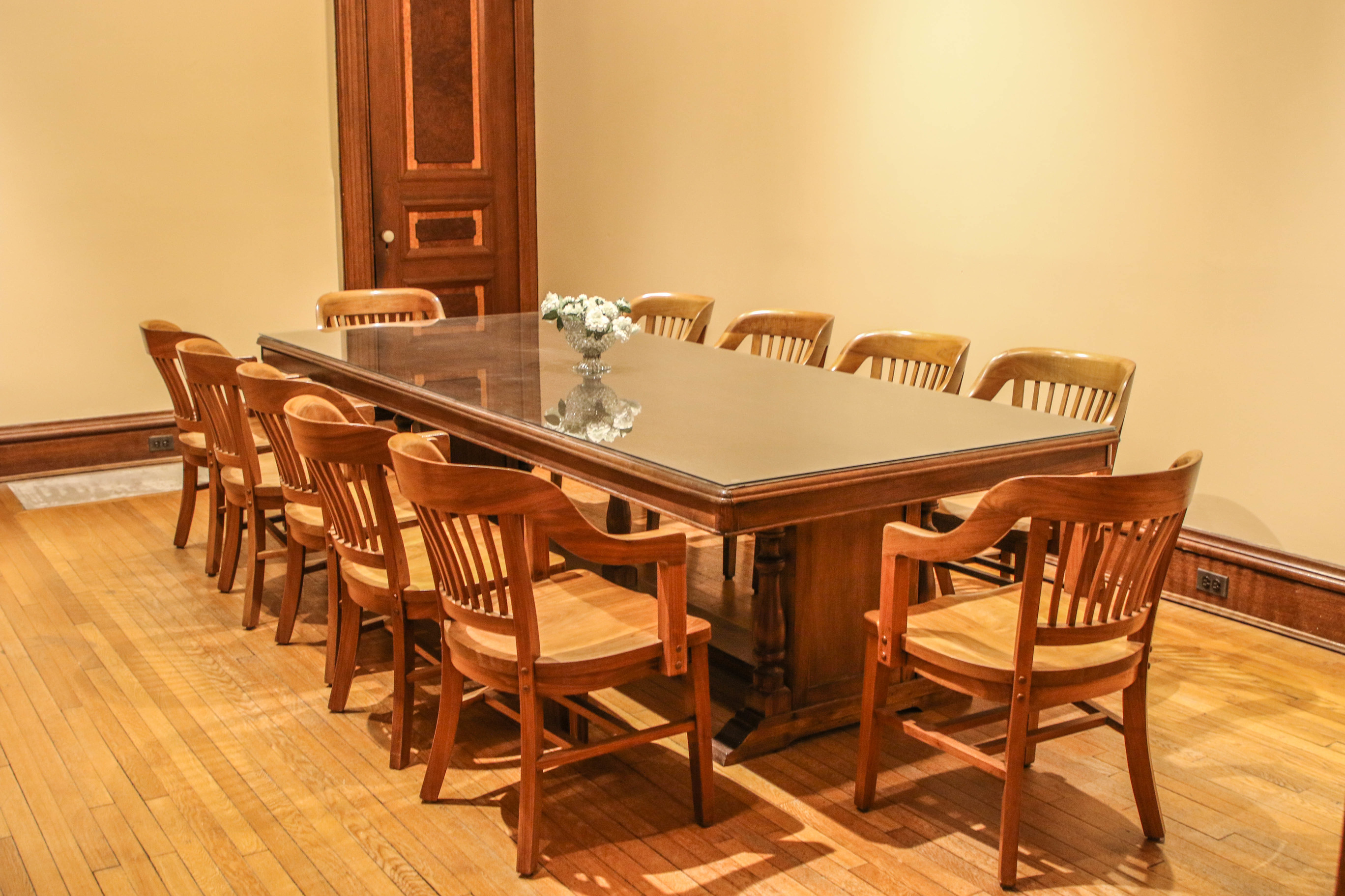 Table decorated with a flower vase and surrounded by chairs