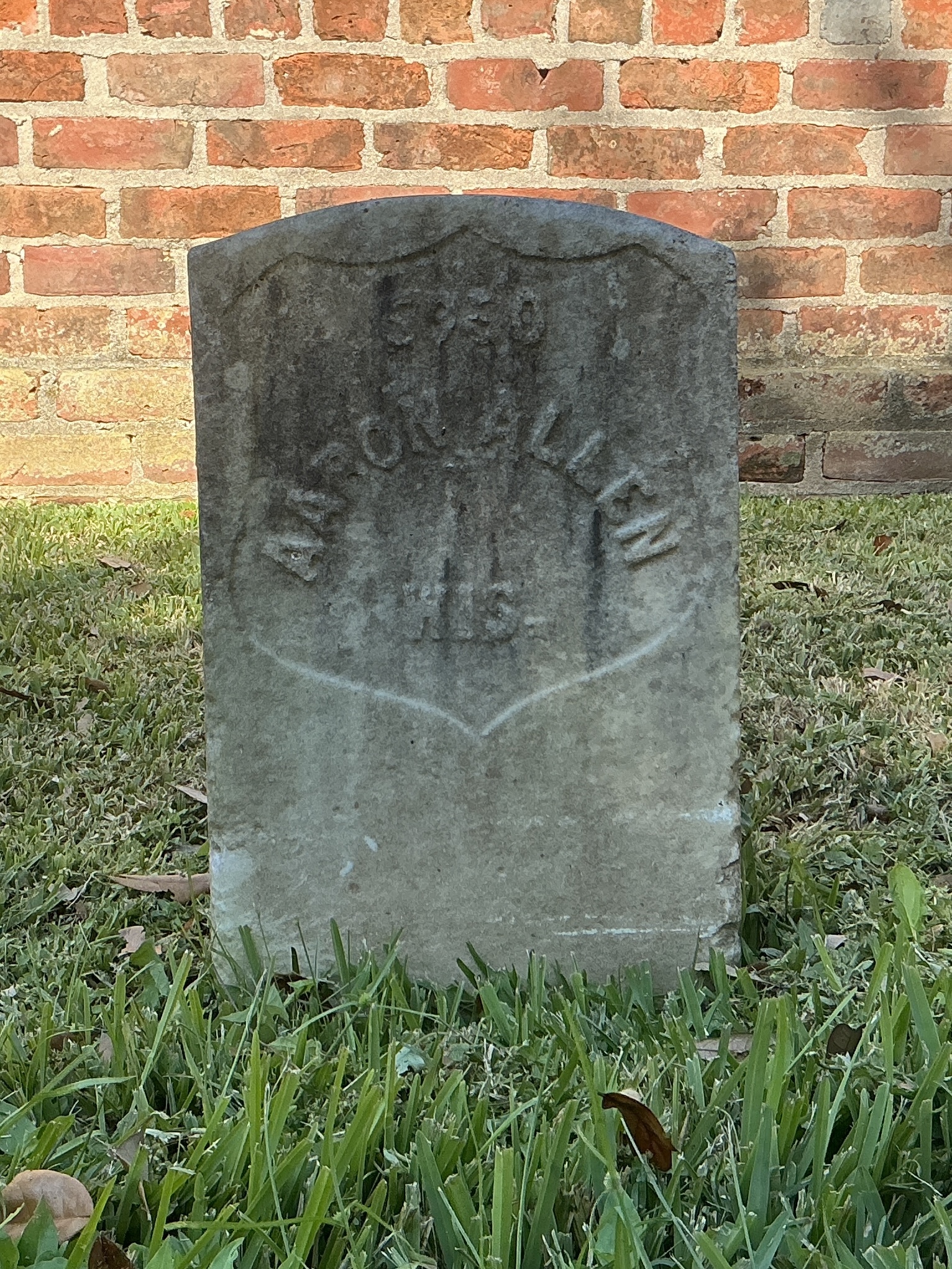 Front of historic upright marble headstone with recessed shield face.