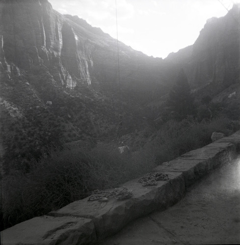Completed rock retaining wall alongside road at the Zion-Mt. Carmel Highway tunnel, canyon in the background.